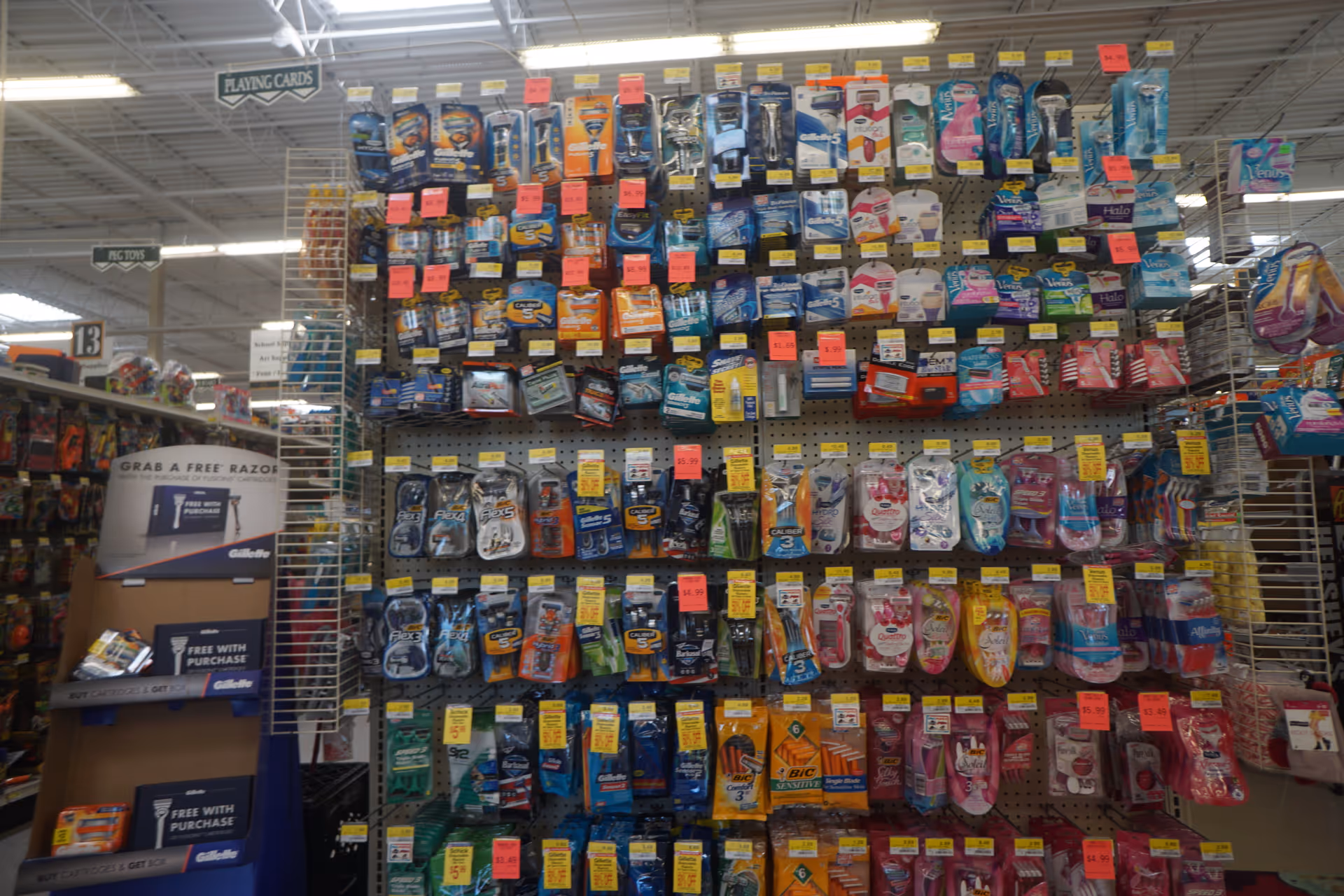 A crowded retail display wall of assorted personal care products inside a Discount Drug Mart.