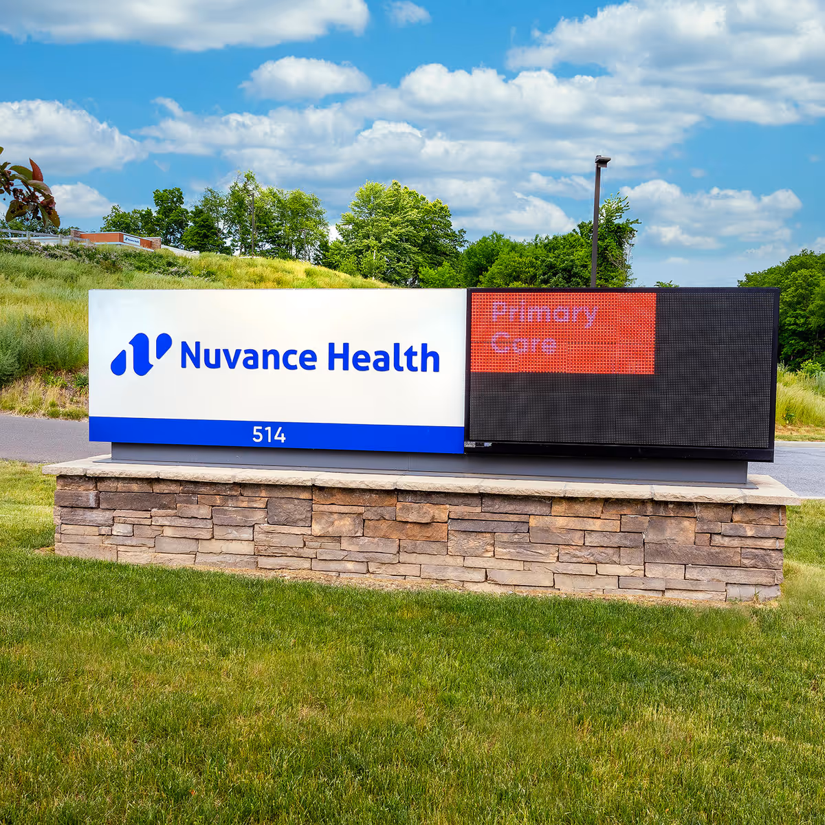 Outdoor sign on a stone base displays Nuvance Health with a digital panel.