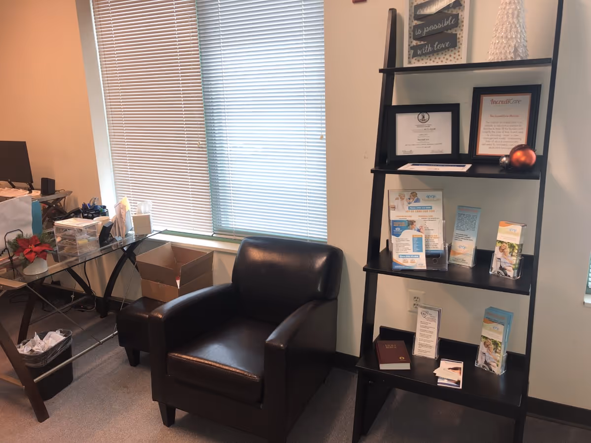 Office-like waiting area in IncrediCare facility with chair and brochure shelf.