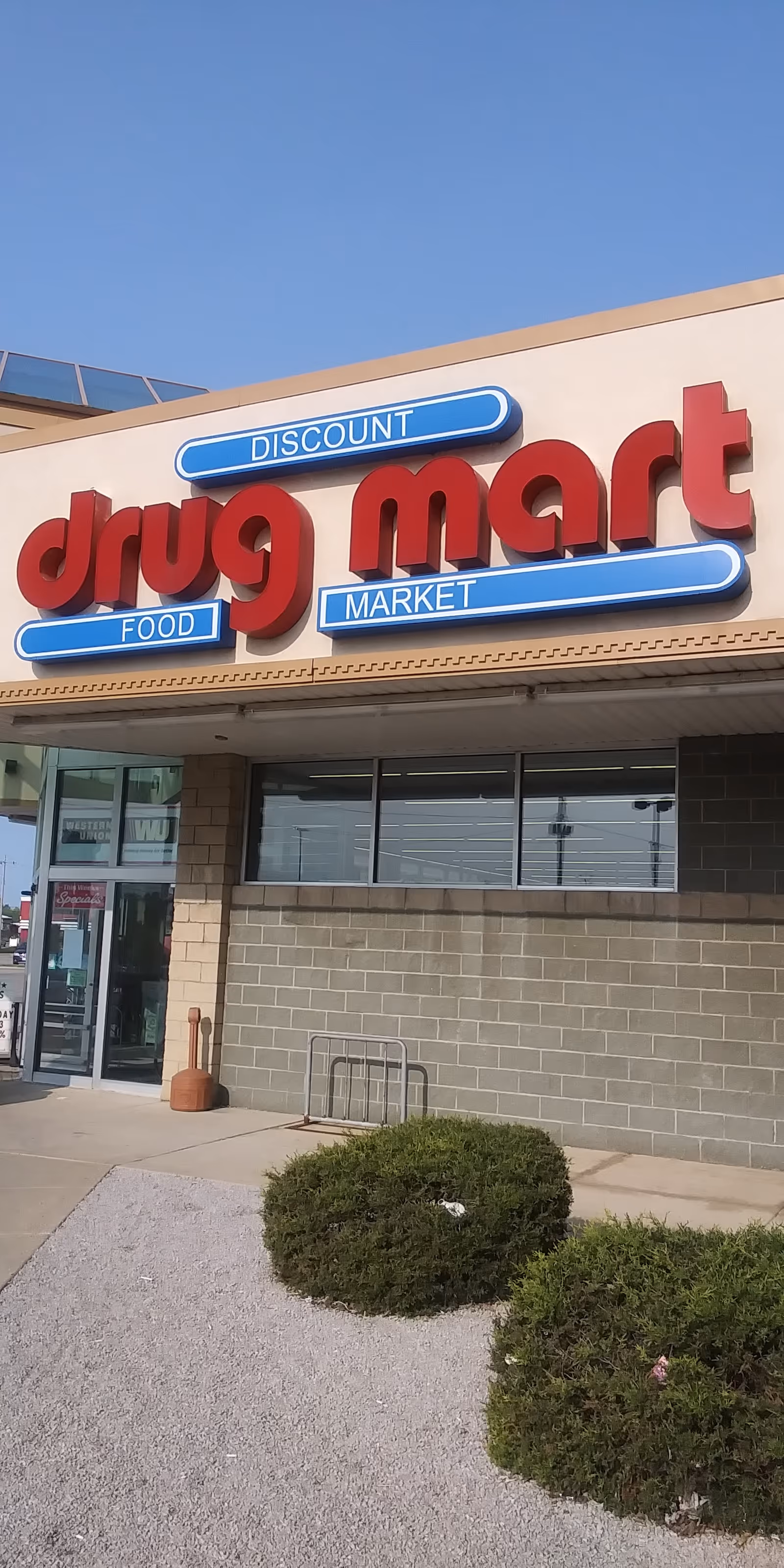 Exterior storefront of Discount Drug Mart with red lettering and blue accents.