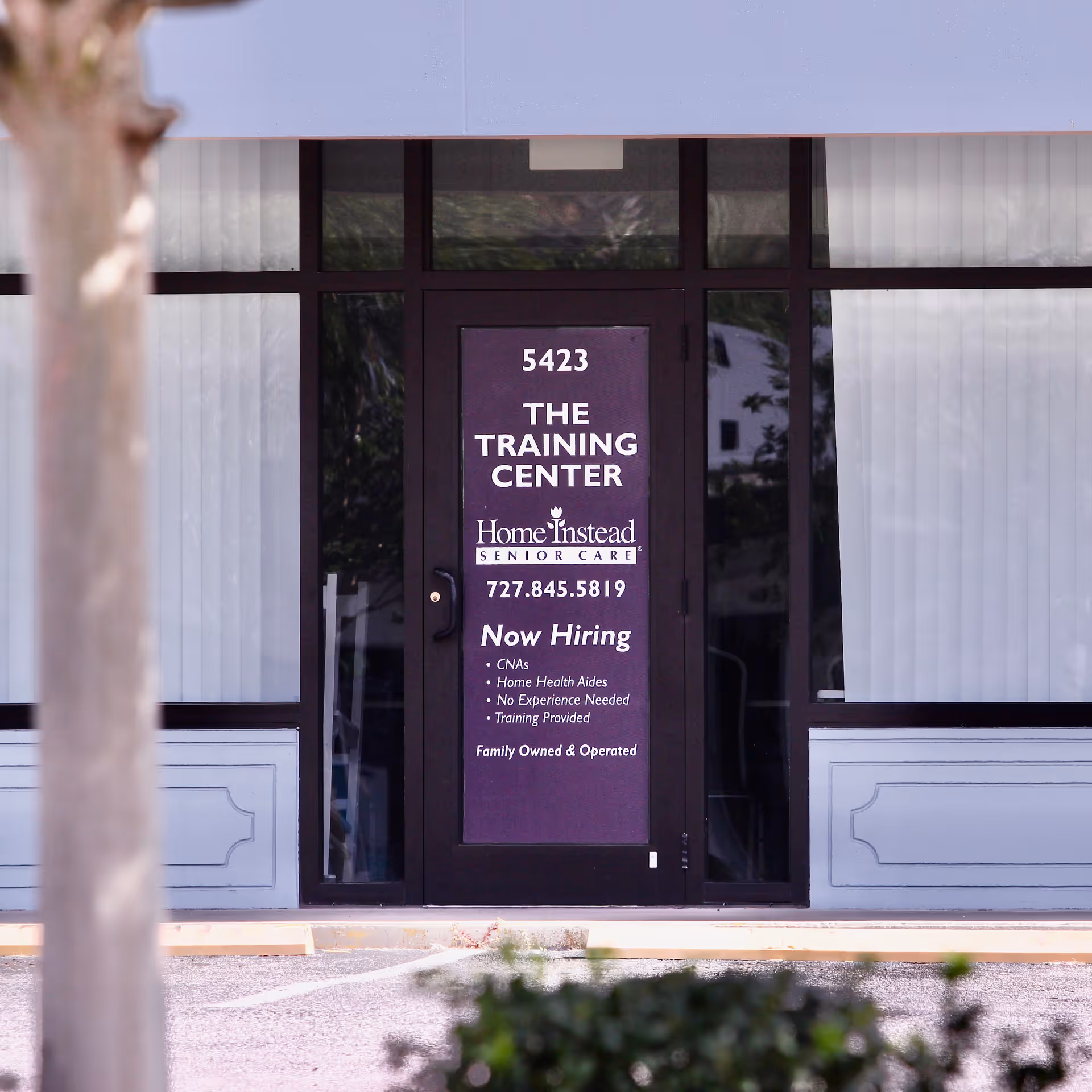 Exterior entrance with a purple sign reading The Training Center for Home Instead Senior Care