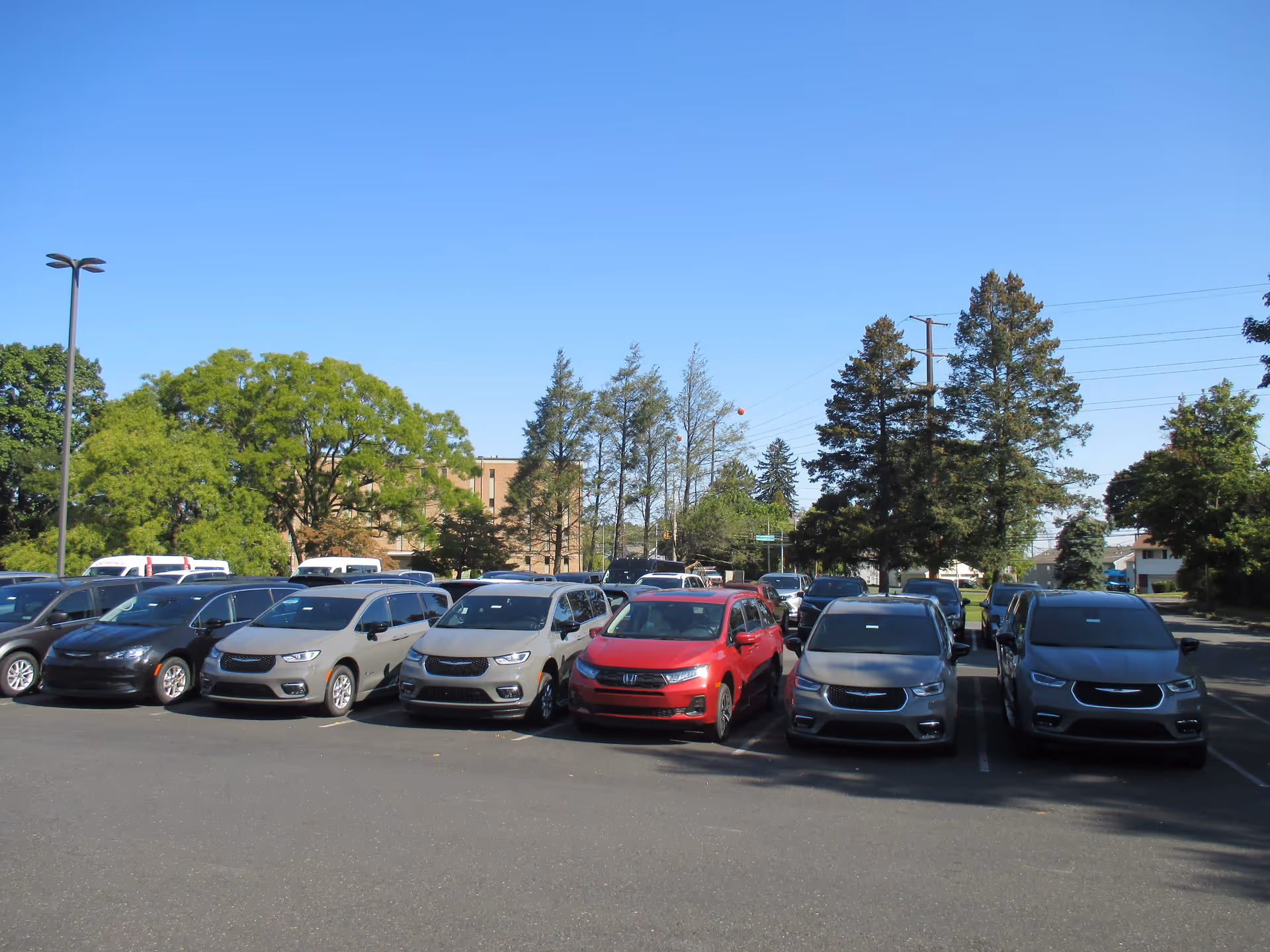 An outdoor parking lot in front of a building with several parked cars.