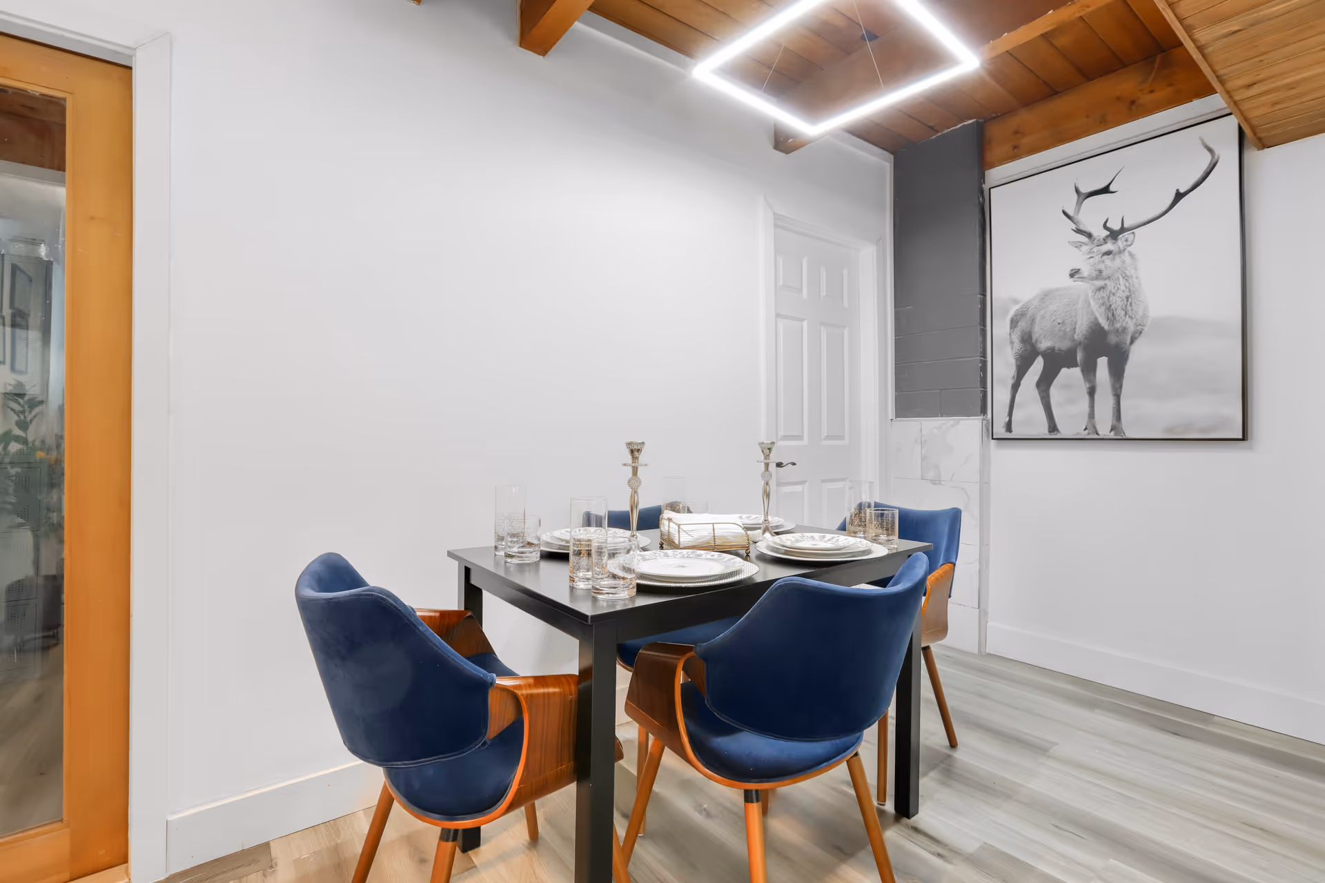 Dining room with a table set for six and blue upholstered chairs.
