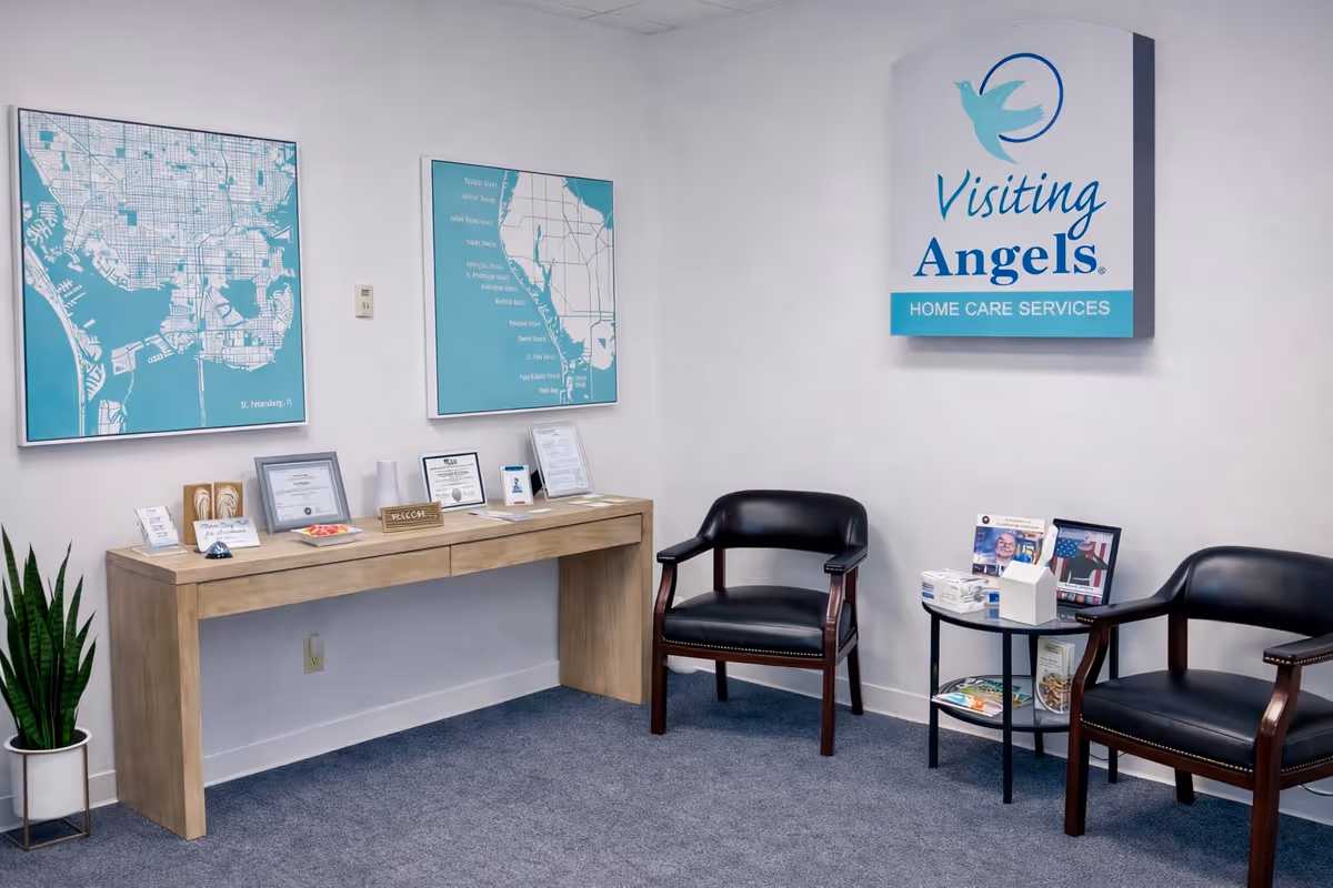 A waiting area with chairs, a console table, maps, and a Visiting Angels sign.