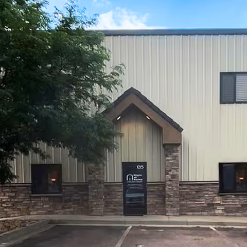 Exterior view of Right at Home facility entrance with stone accents and a peaked awning.