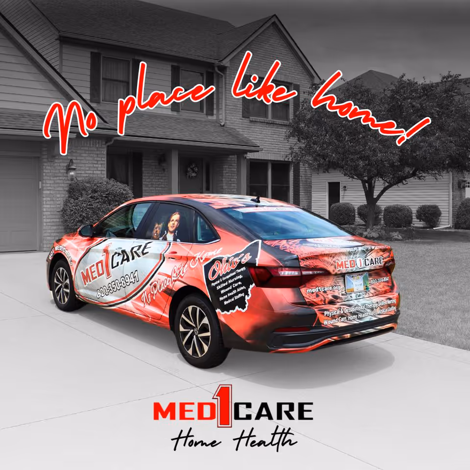 Red Med1Care promotional car parked in a suburban driveway with a house background.