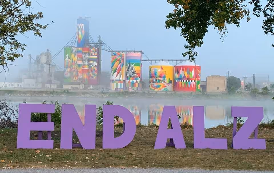 Colorful outdoor installation along a misty riverfront, featuring large END ALZ letters.