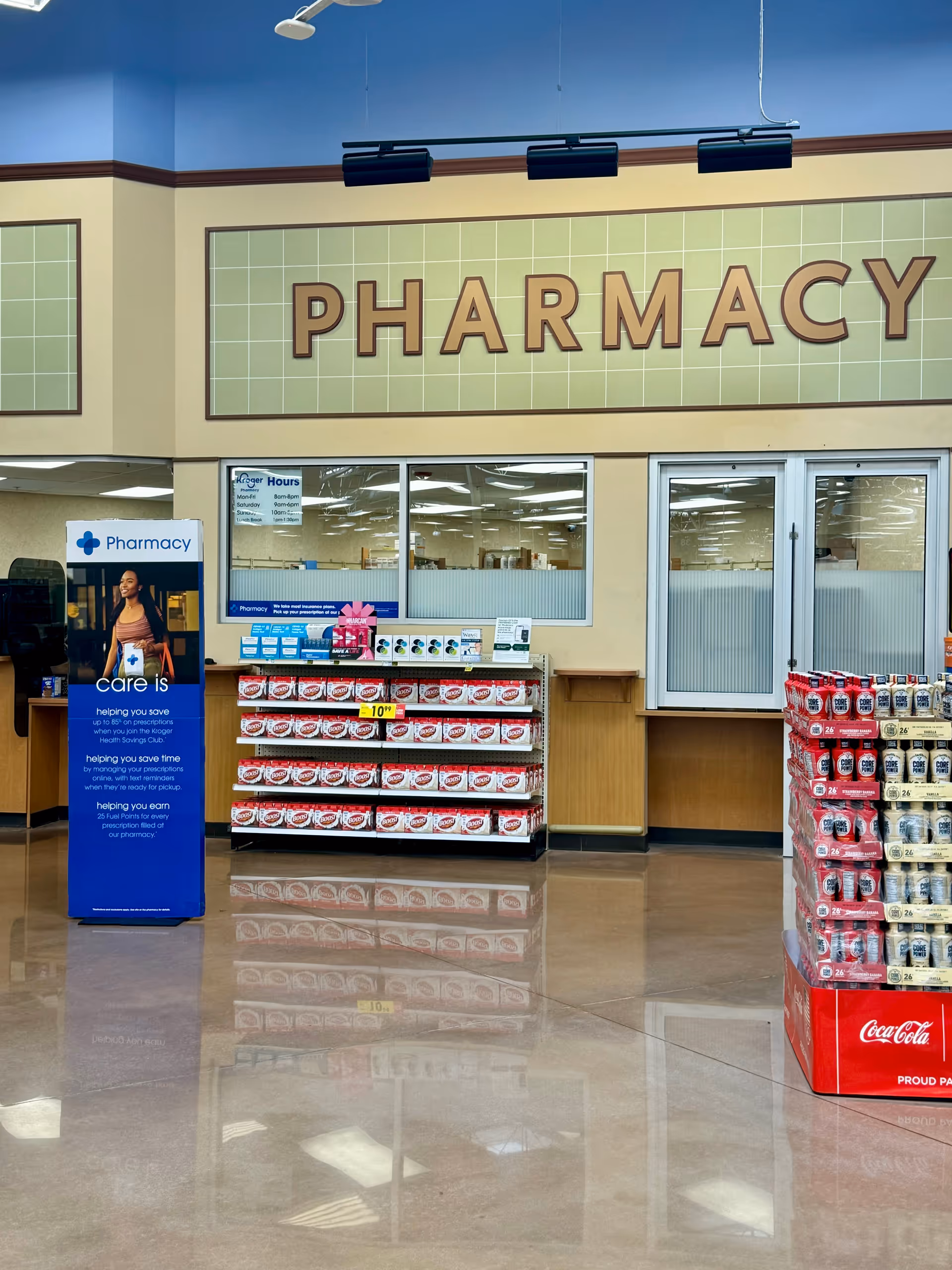 Inside a Kroger Pharmacy area with shelves, displays, and a large PHARMACY sign.