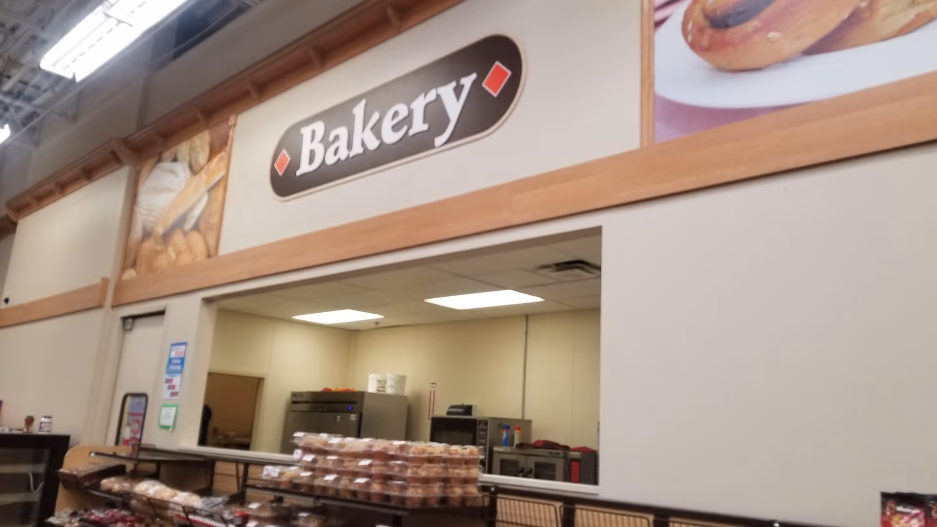 Interior bakery counter in a facility with pastries on display behind a serving window.