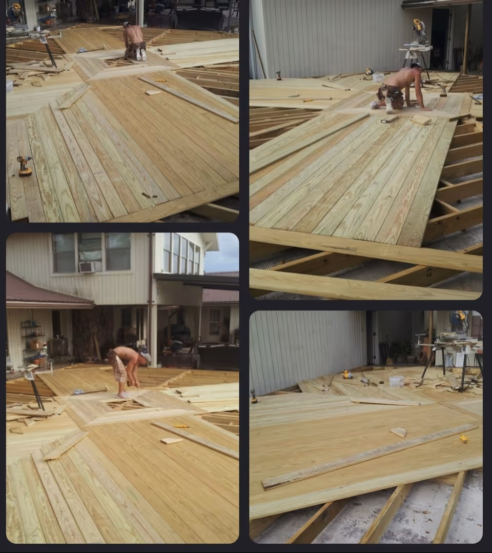 A worker installs wooden floorboards inside a residential structure under remodeling.