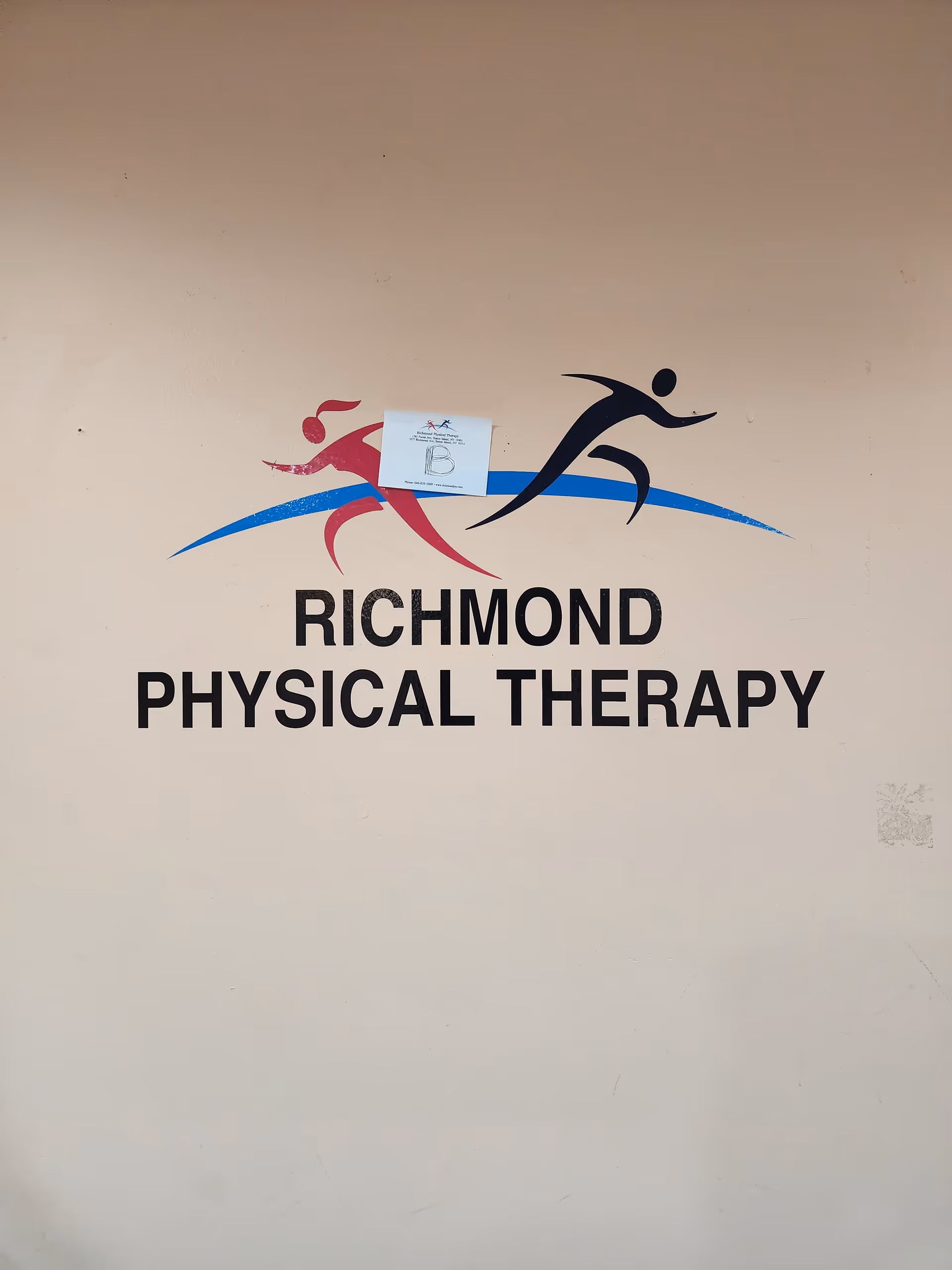 Beige wall featuring Richmond Physical Therapy logo with colorful running figures.