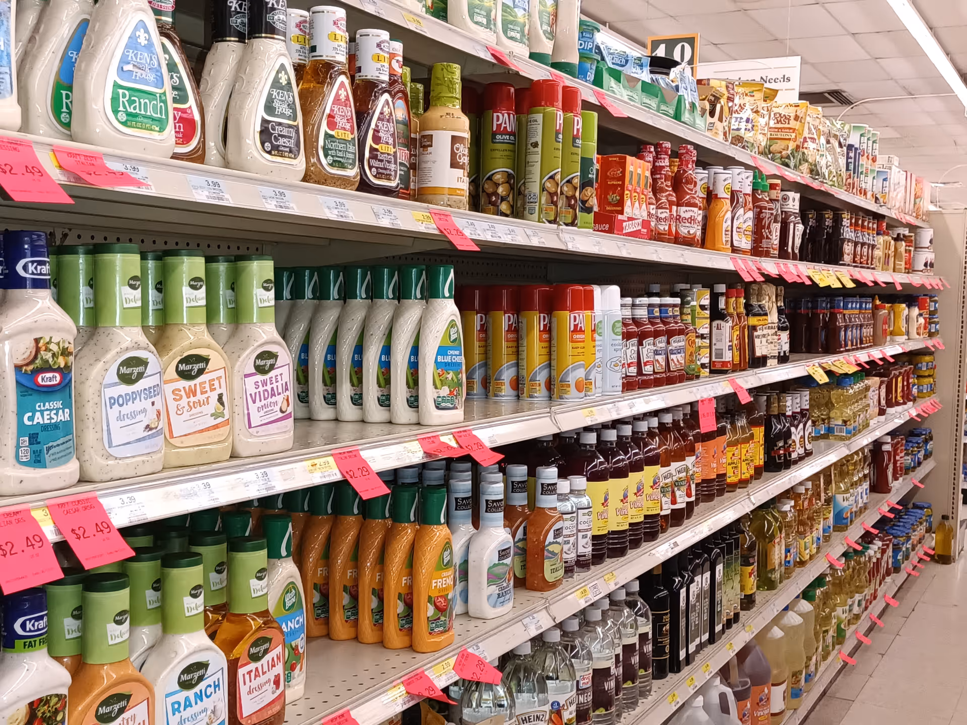 A supermarket aisle lined with shelves full of condiments and bottled sauces.