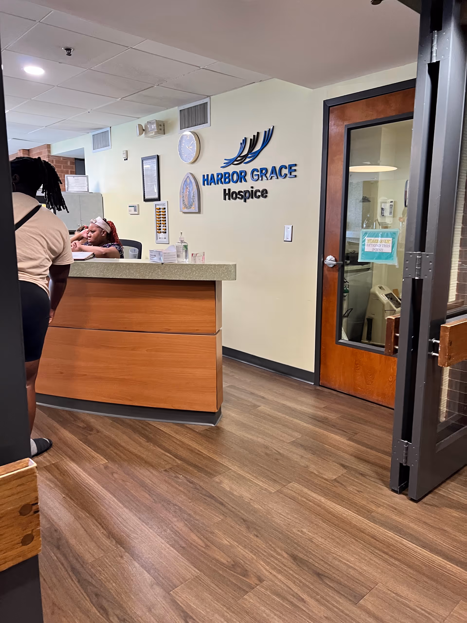 Reception desk area inside Harbor Grace Hospice with a sign on the wall.