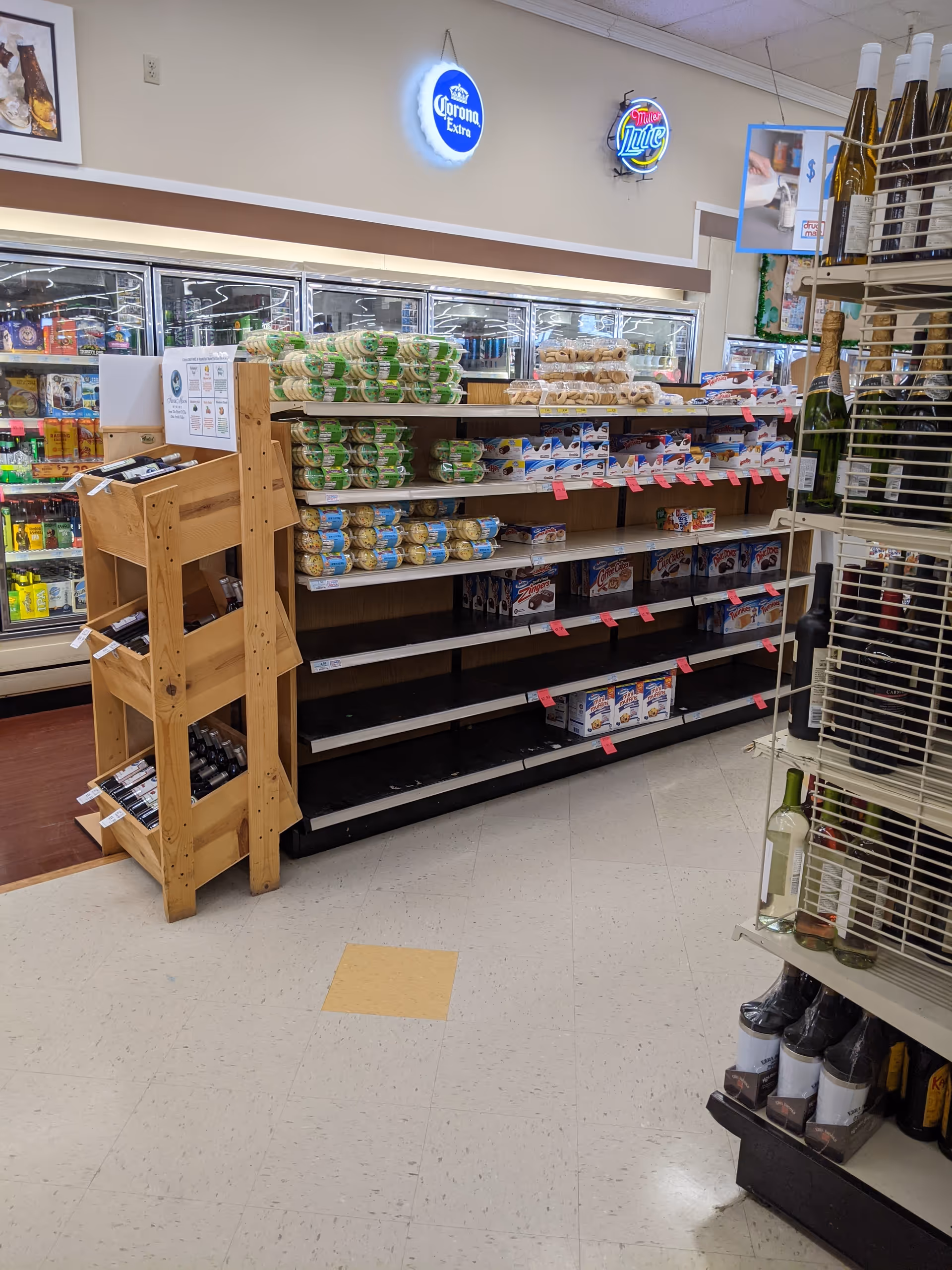Interior view of a Discount Drug Mart aisle with refrigerated sections and snack shelves.