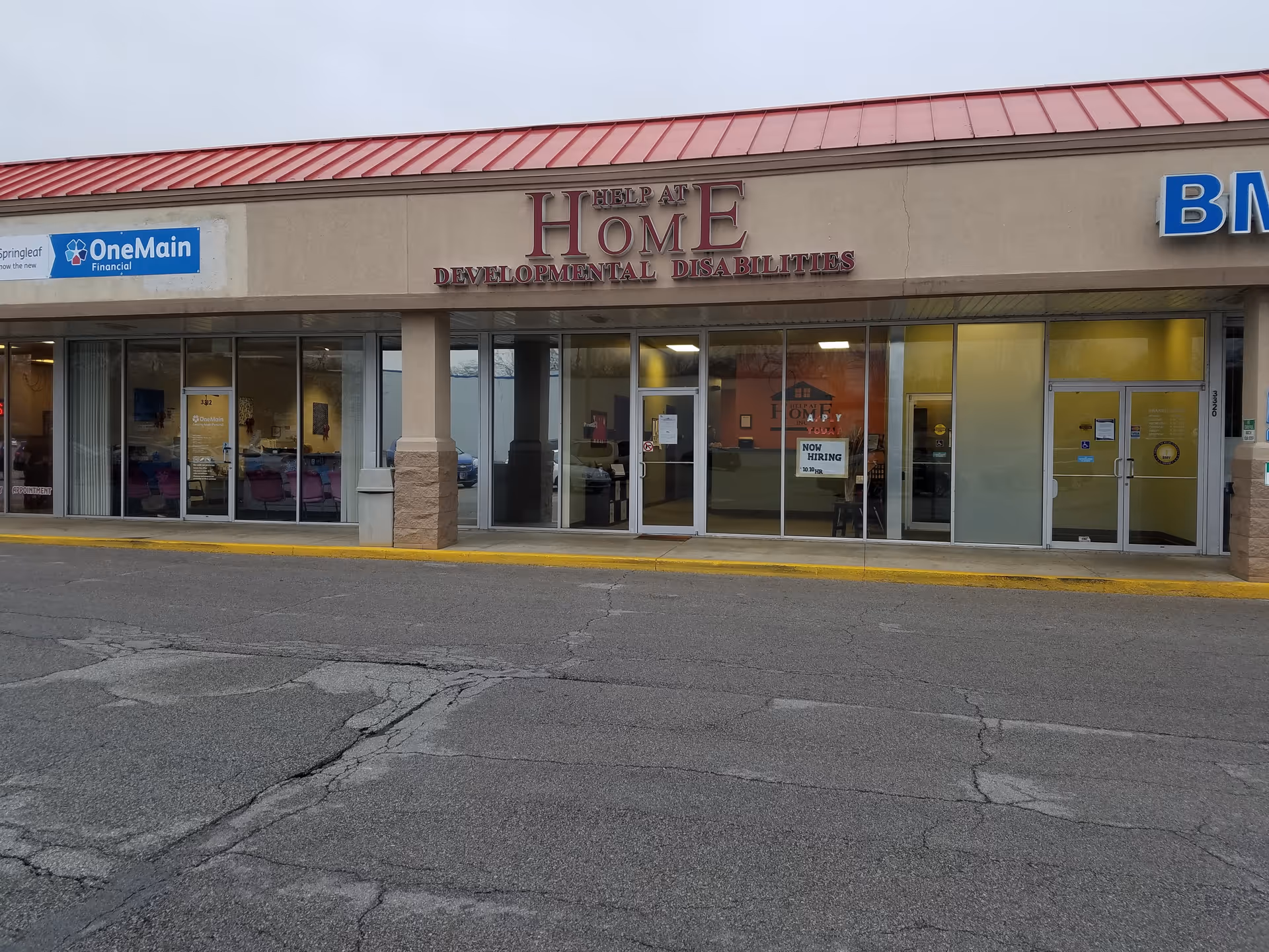 Exterior storefront of Help at Home Developmental Disabilities center across a strip mall.