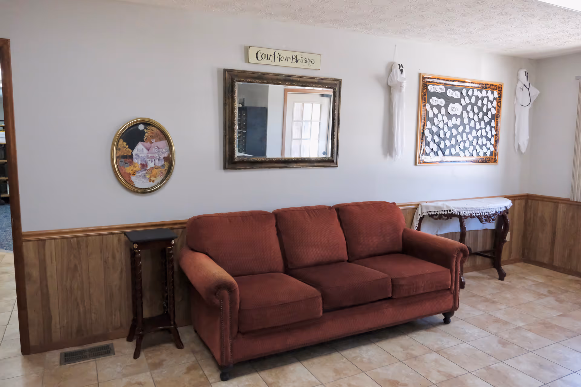 Red sofa in a cozy living room with wall art and a side table.