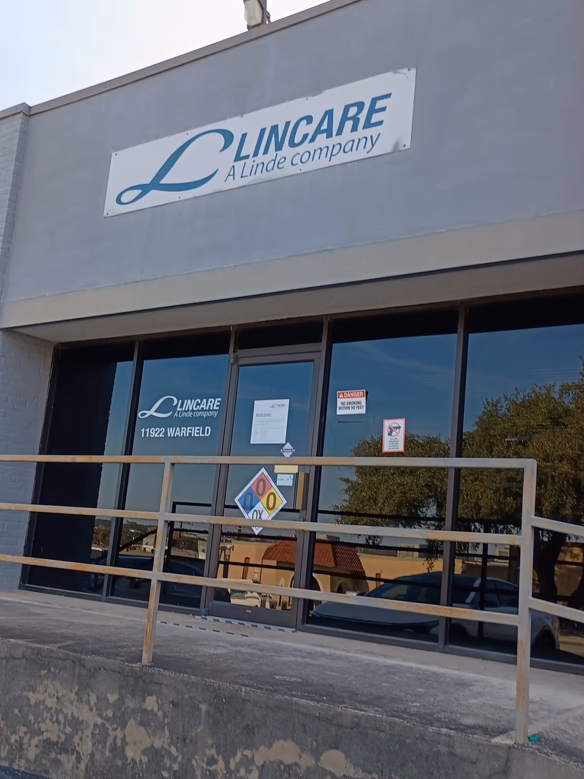 Exterior view of LINCARE facility with sign, glass doors, and railing.
