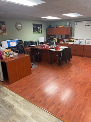 Office workspace inside Independence Assistance Inc. with desks, computers, and filing cabinets.