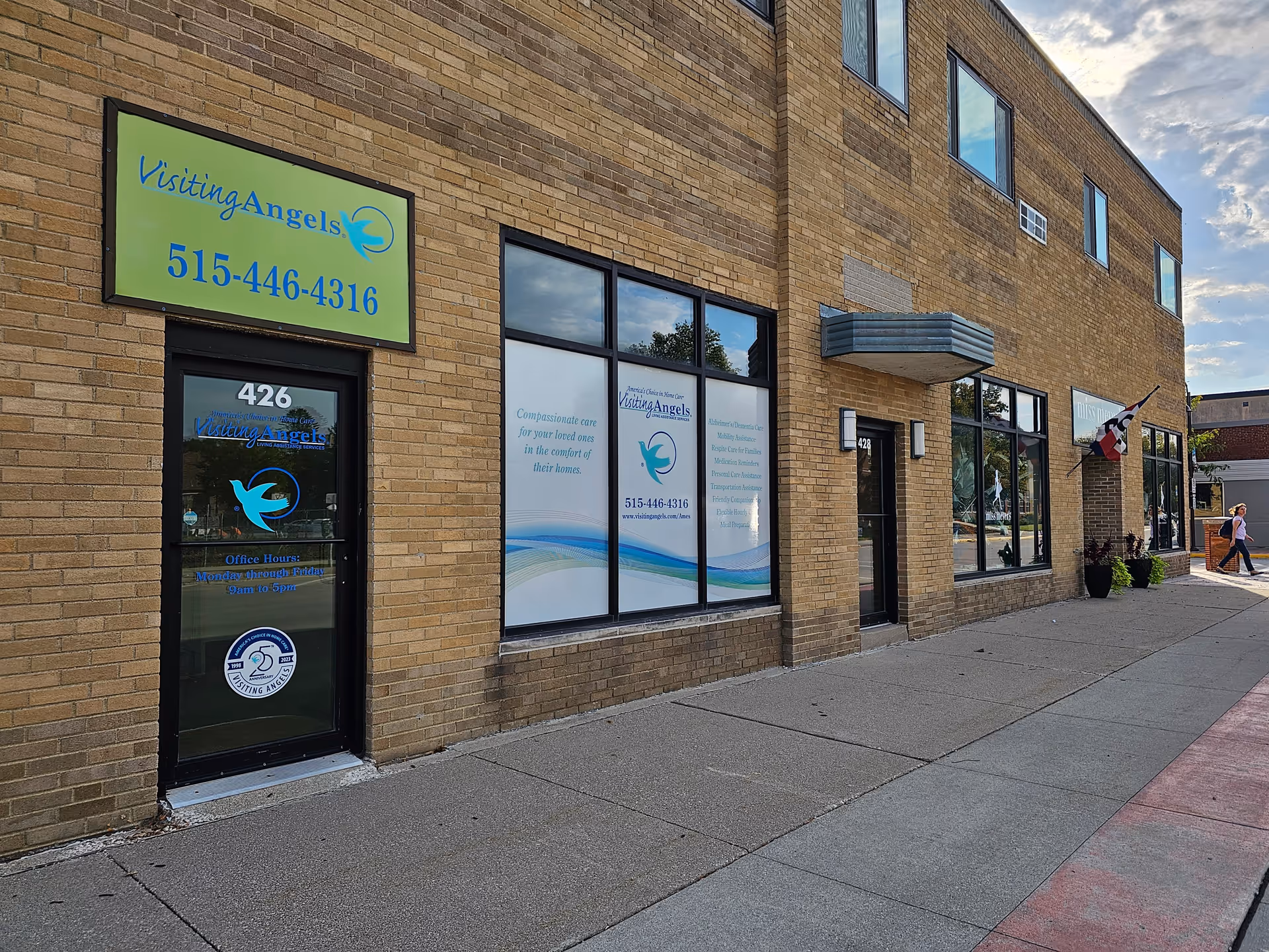 Brick exterior of Visiting Angels Senior Home Care building with large windows and sign.