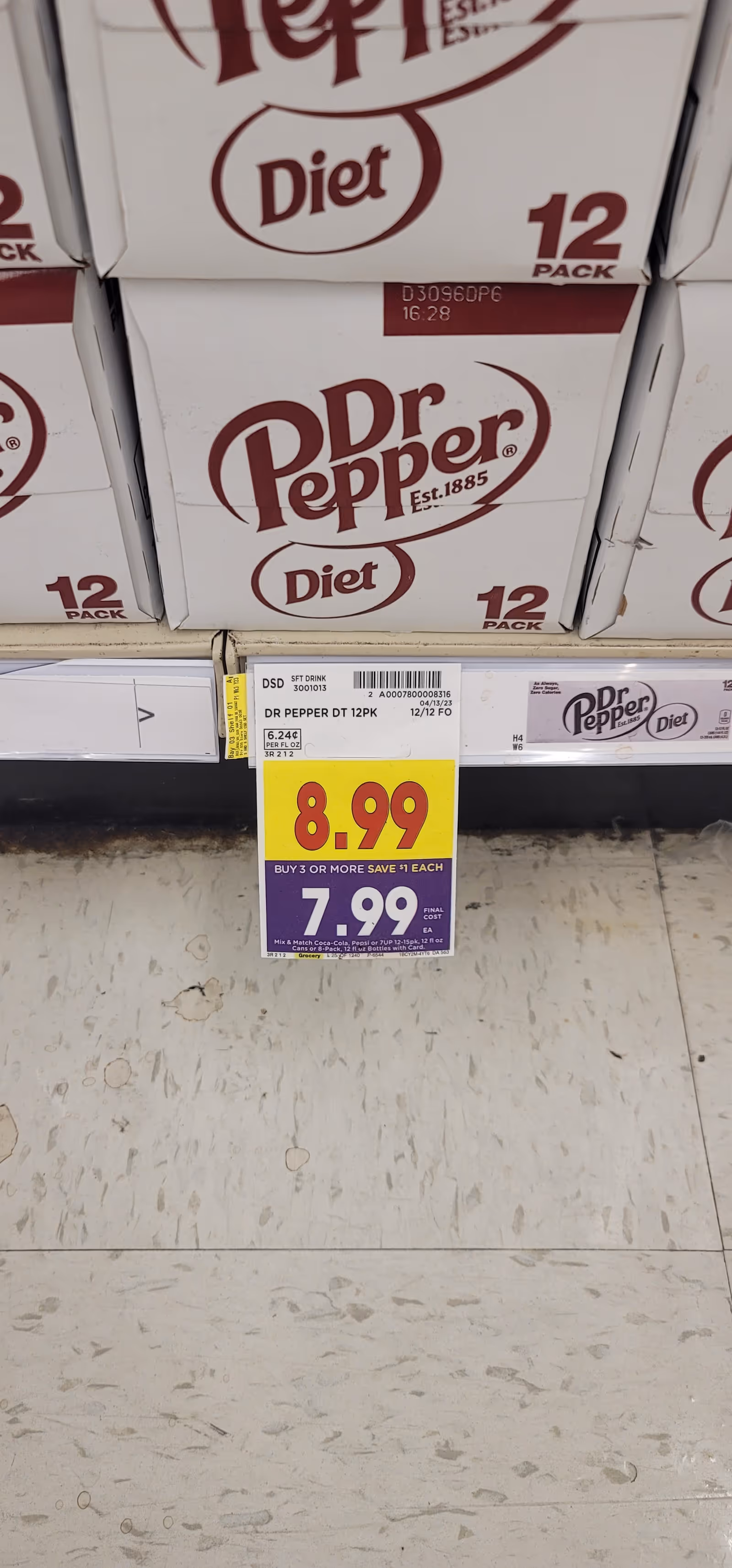 Boxes of Dr Pepper Diet 12-packs stacked on a store shelf with a sale sign