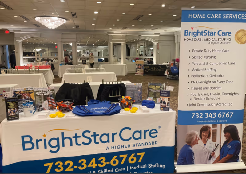 BrightStar Care booth with banners and tables in a conference hall.