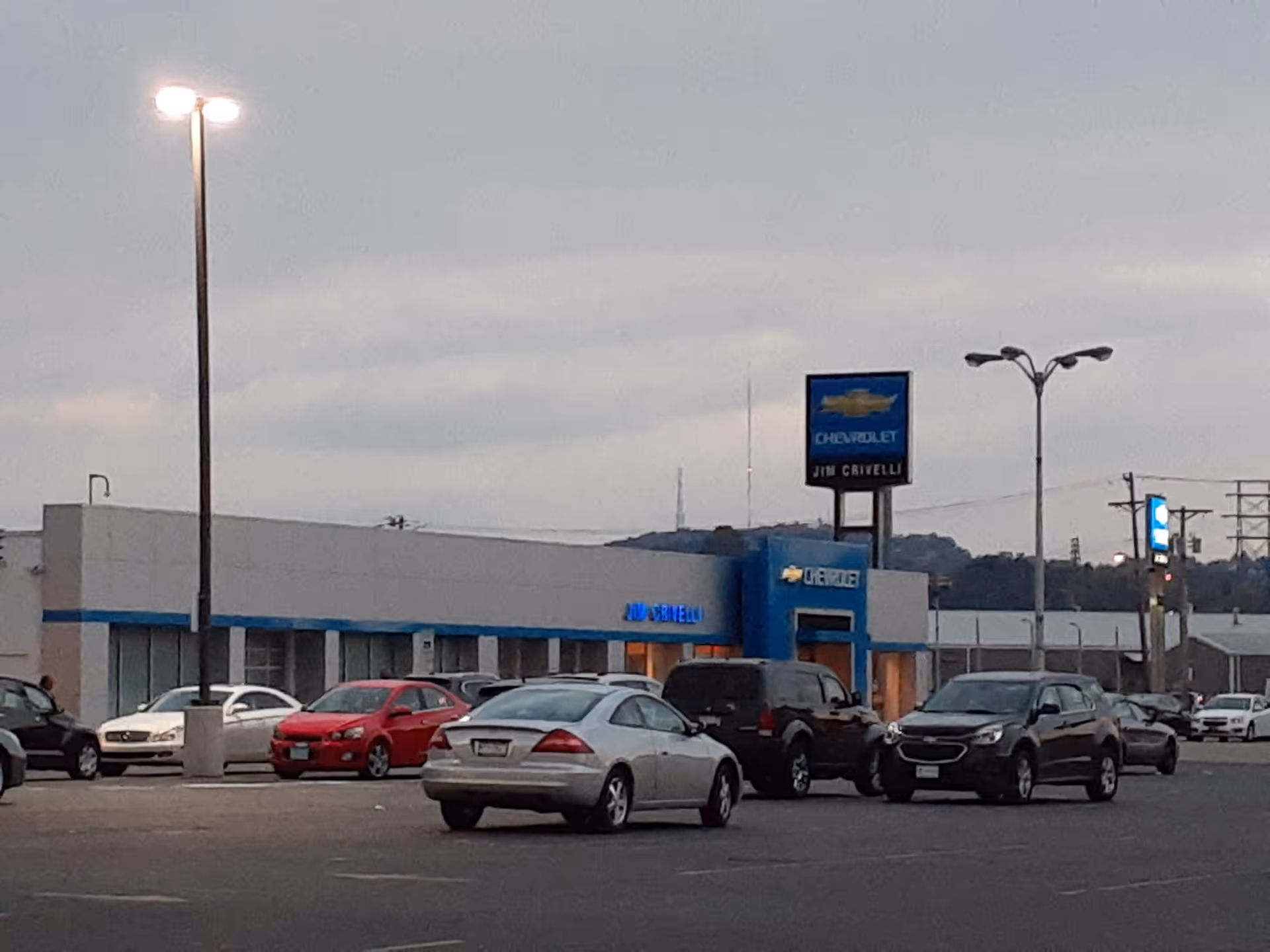 Exterior view of a blue-and-white building with a Chevrolet sign and parked cars.