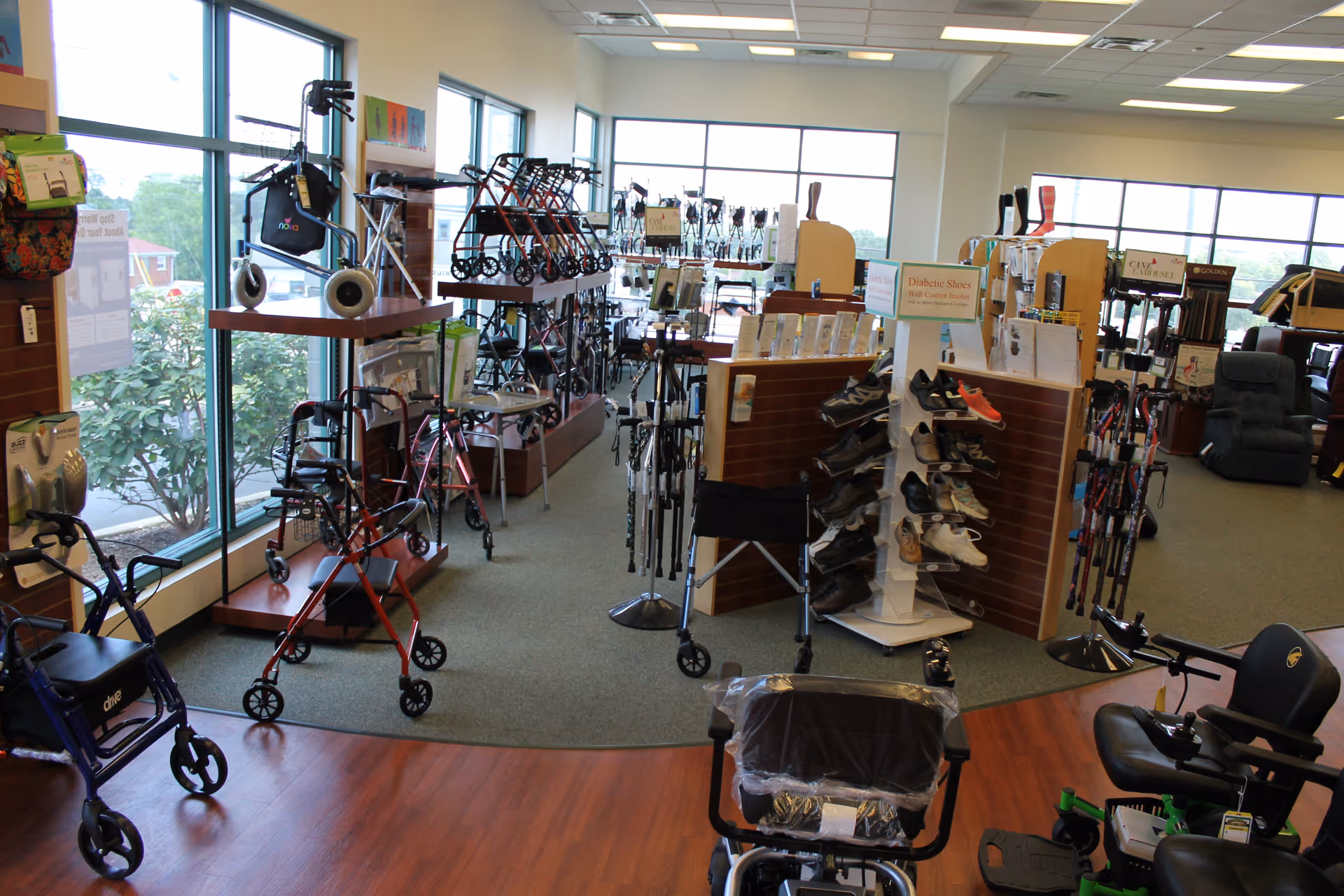 Indoor showroom displaying mobility aids and footwear near large windows.