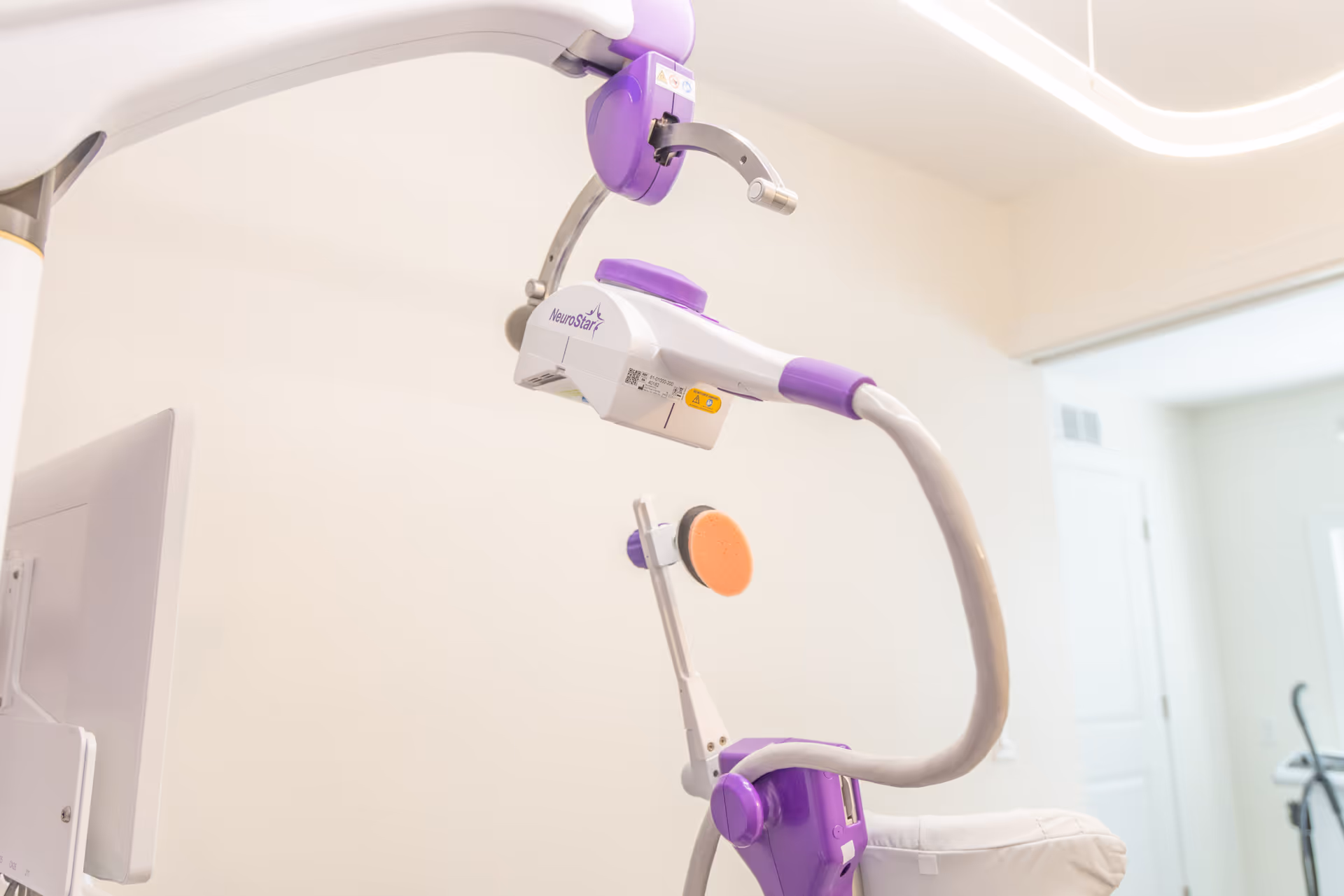 Medical imaging/therapy device with purple accents in a bright clinic room.