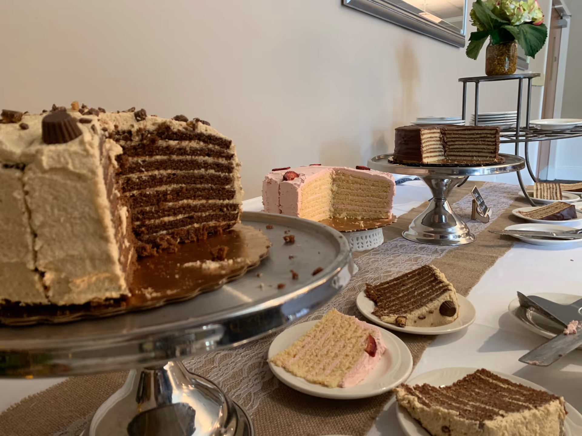 An assortment of cake slices and desserts arranged on a decorated dining table.