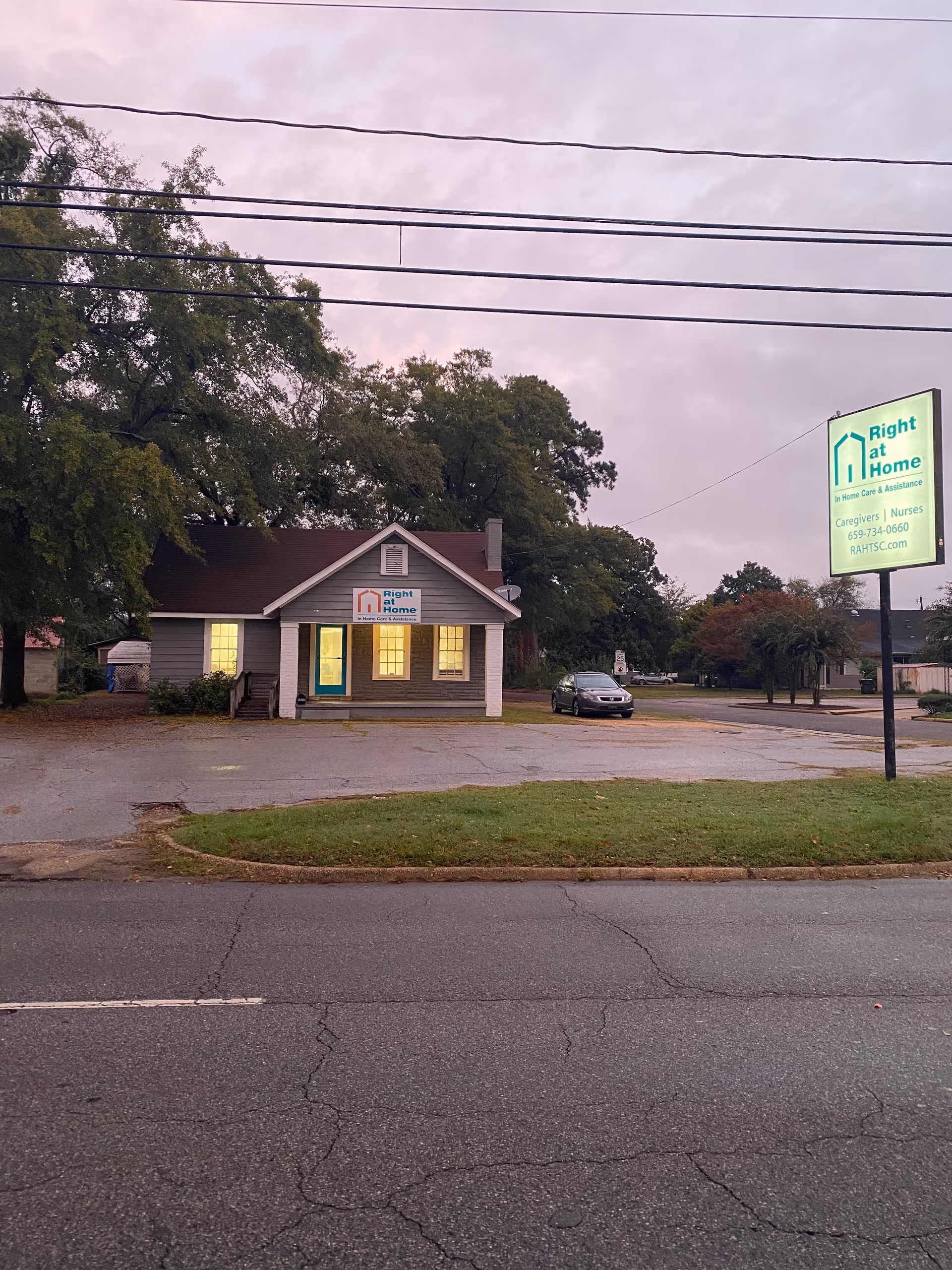Exterior view of a Right at Home facility with sign and parking