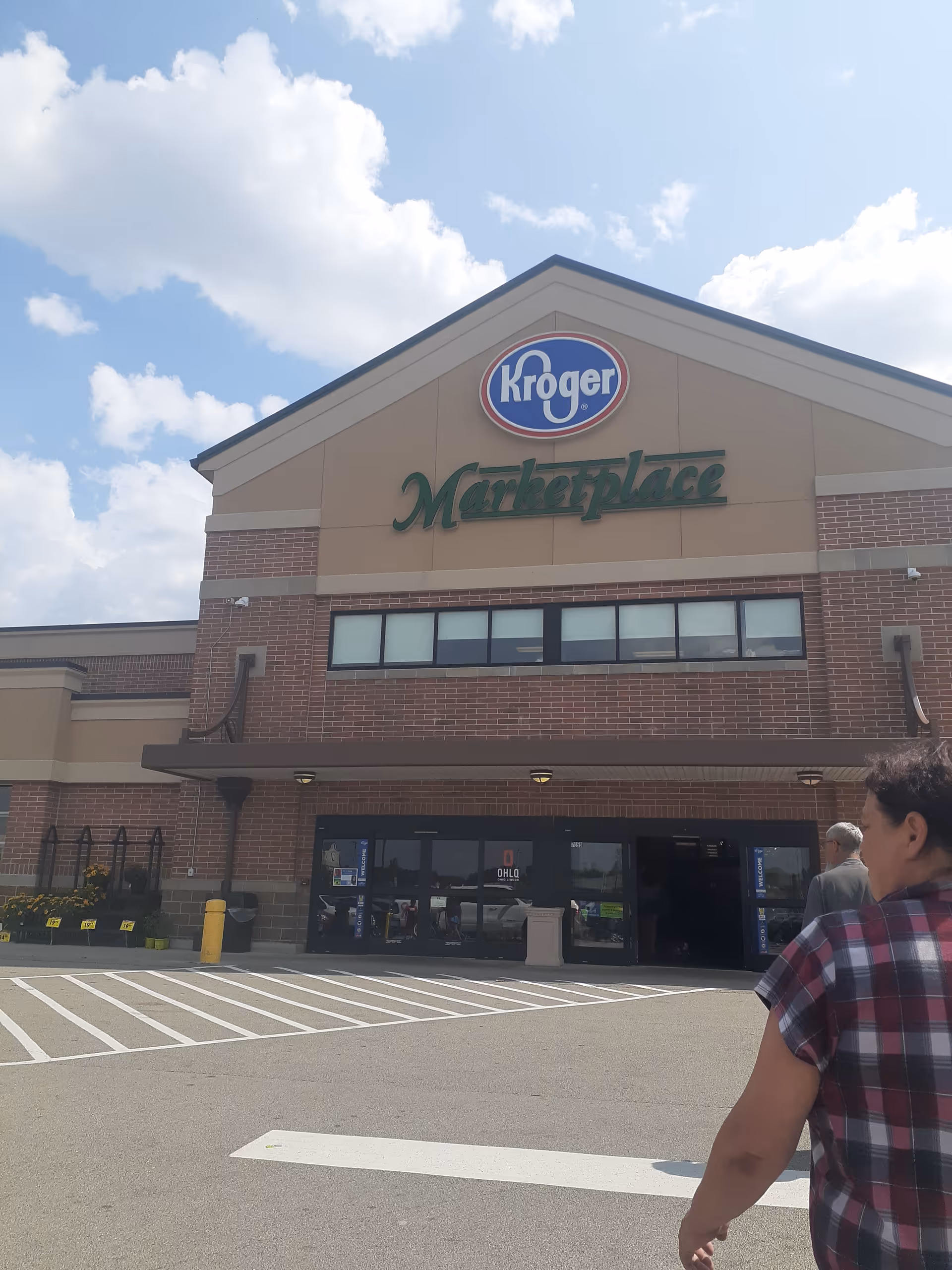 Exterior view of a Kroger MarketPlace store with a parking lot and shoppers.