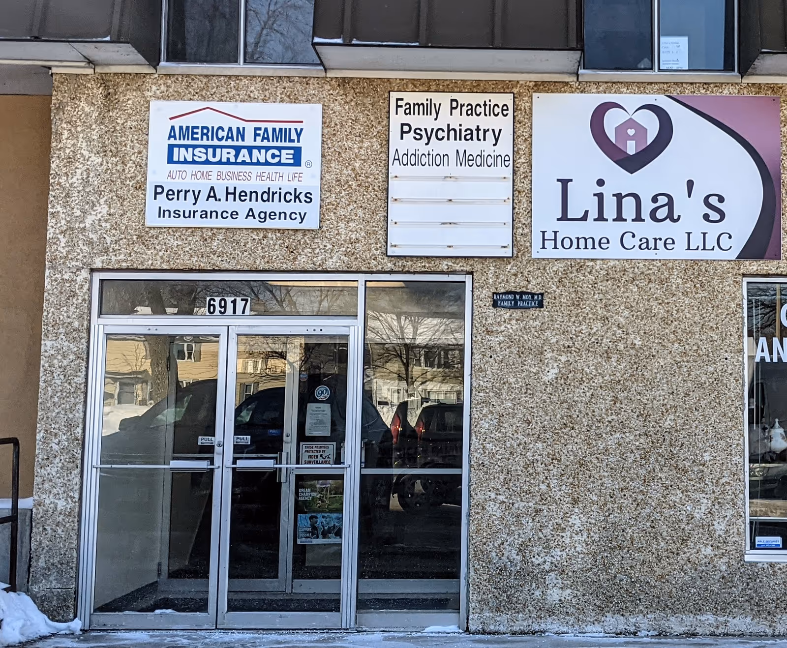 Exterior storefront showing Lina's Home Care LLC sign with glass entrance and other business signs.