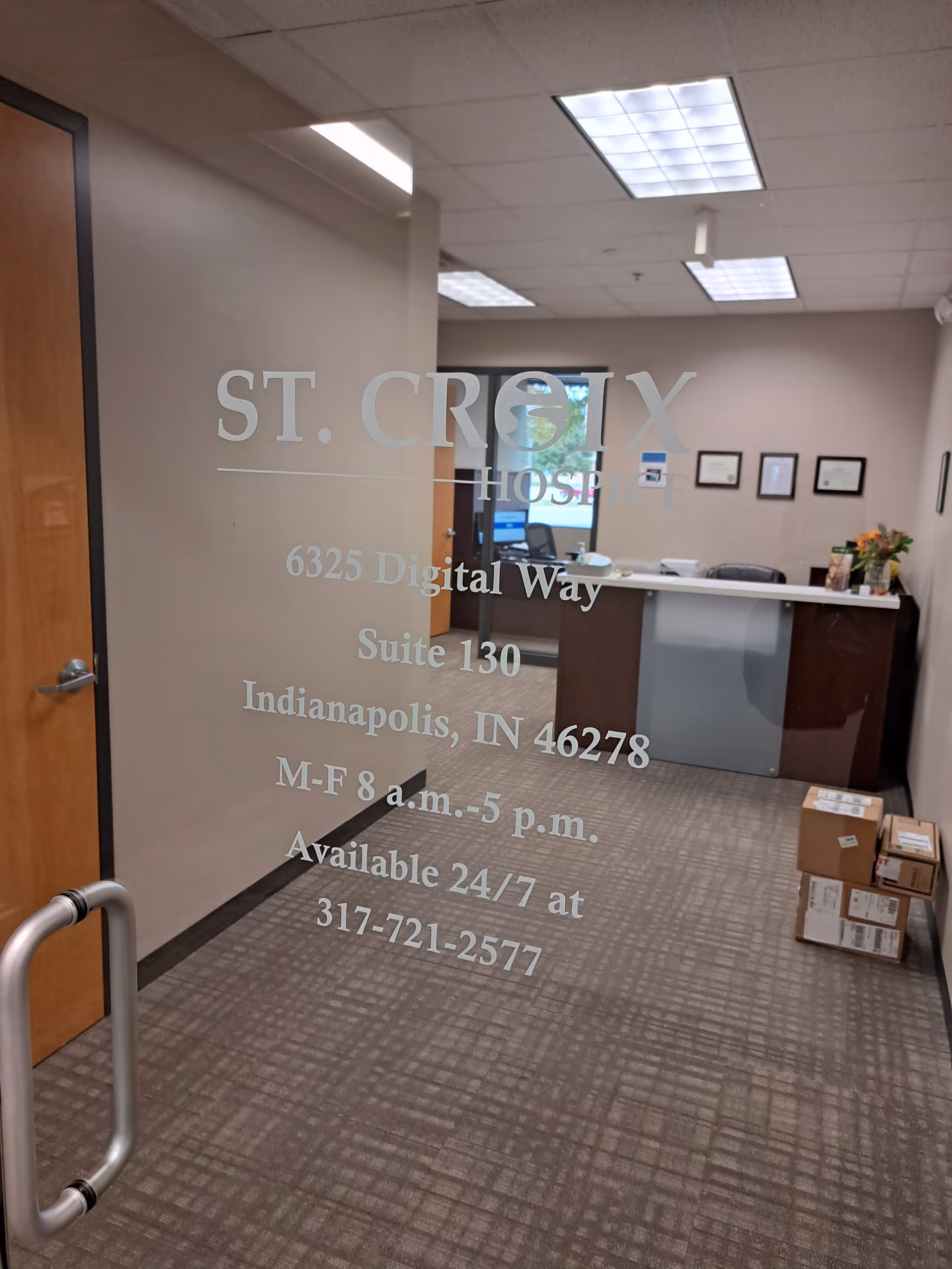 Glass door branded with St. Croix Hospice, revealing a reception desk in a lobby.