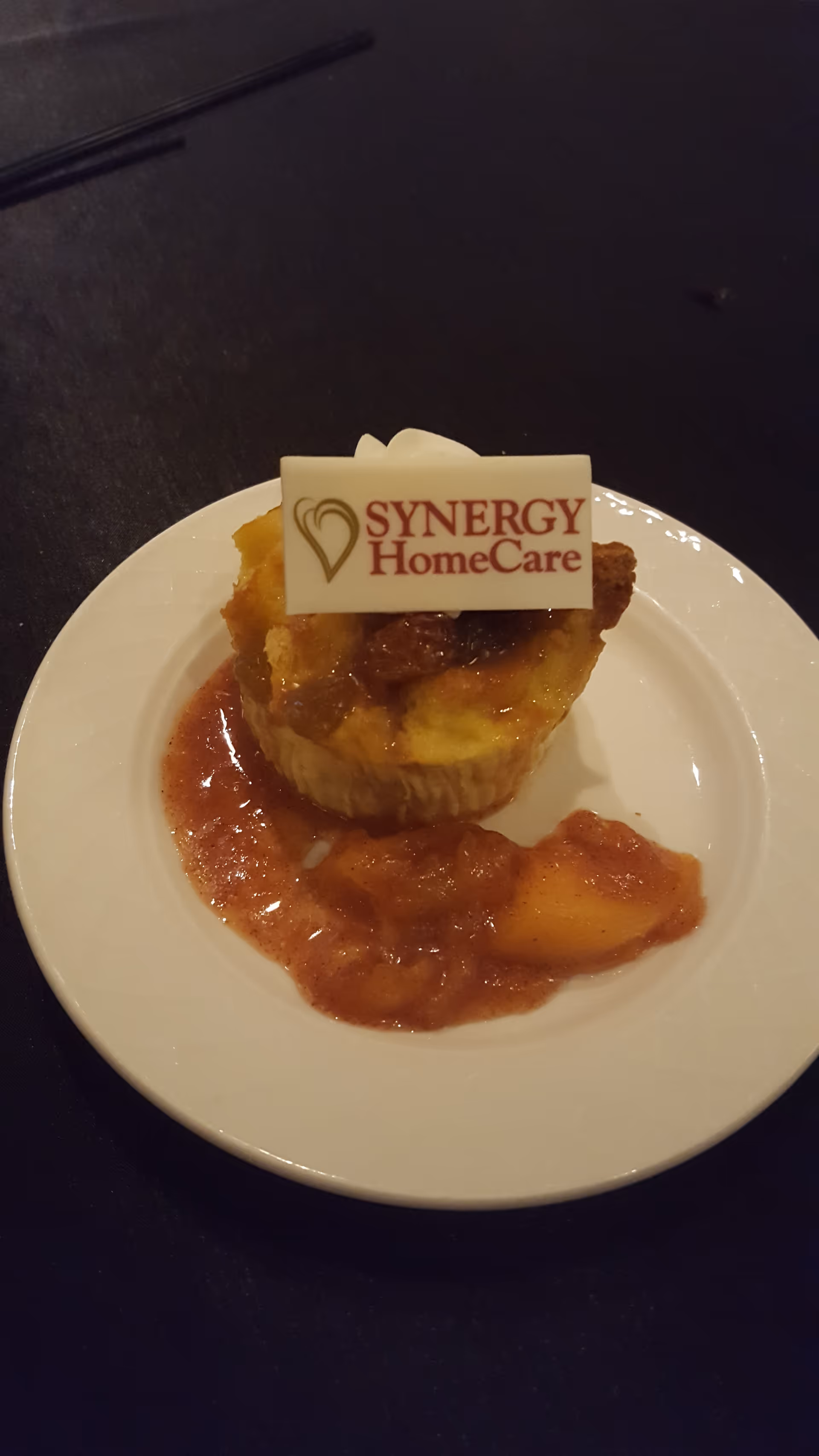 Dessert pastry on a white plate with a SYNERGY HomeCare card on top