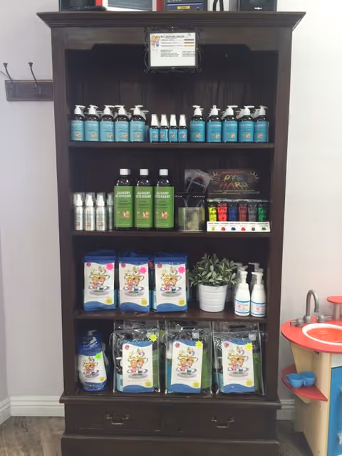 Dark wooden shelf filled with cleaning and laundry products in a small indoor room.