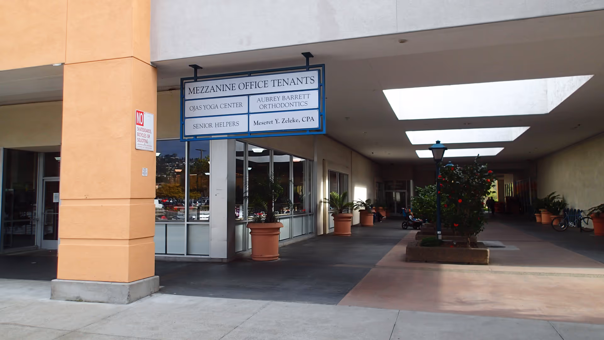 Exterior of a building with storefront and tenant signs including Senior Helpers.