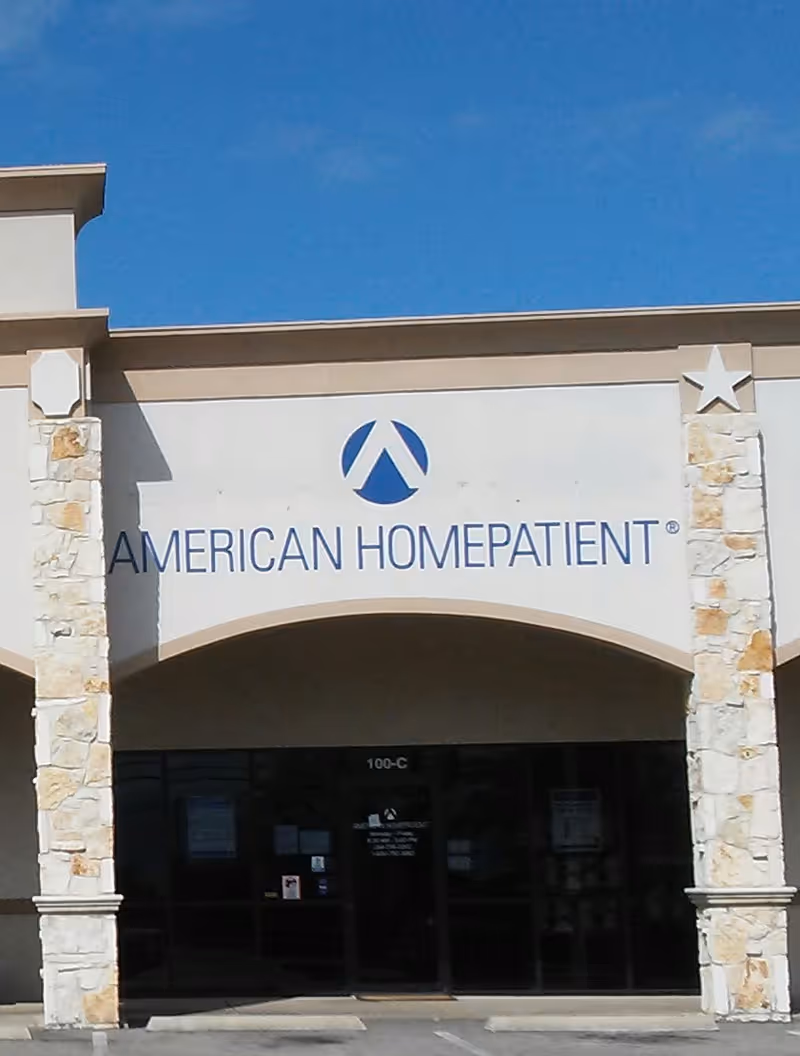 Front facade of American HomePatient with arched entrance and stone pillars.