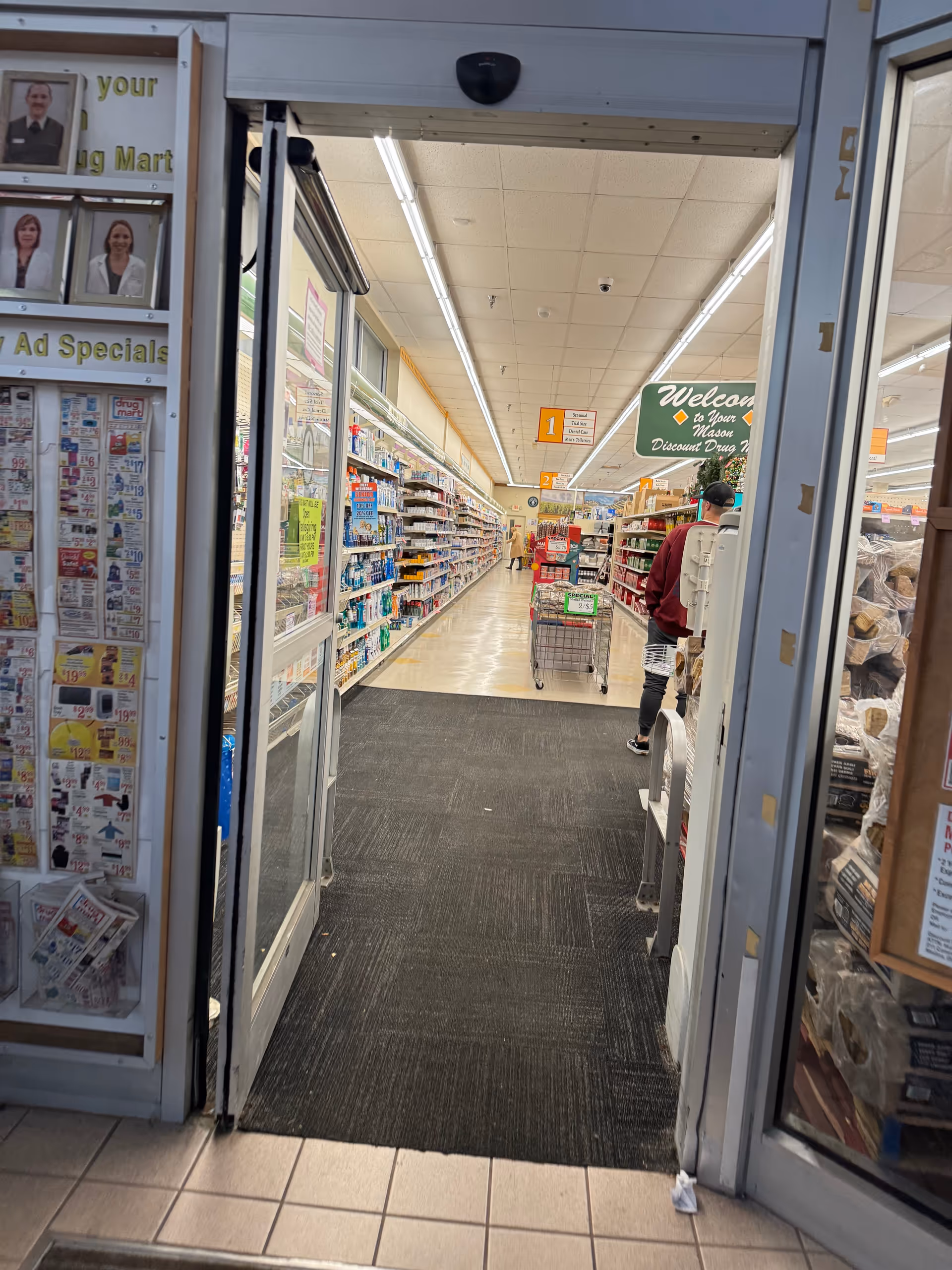 Open entrance to Discount Drug Mart interior with aisles and shoppers browsing.