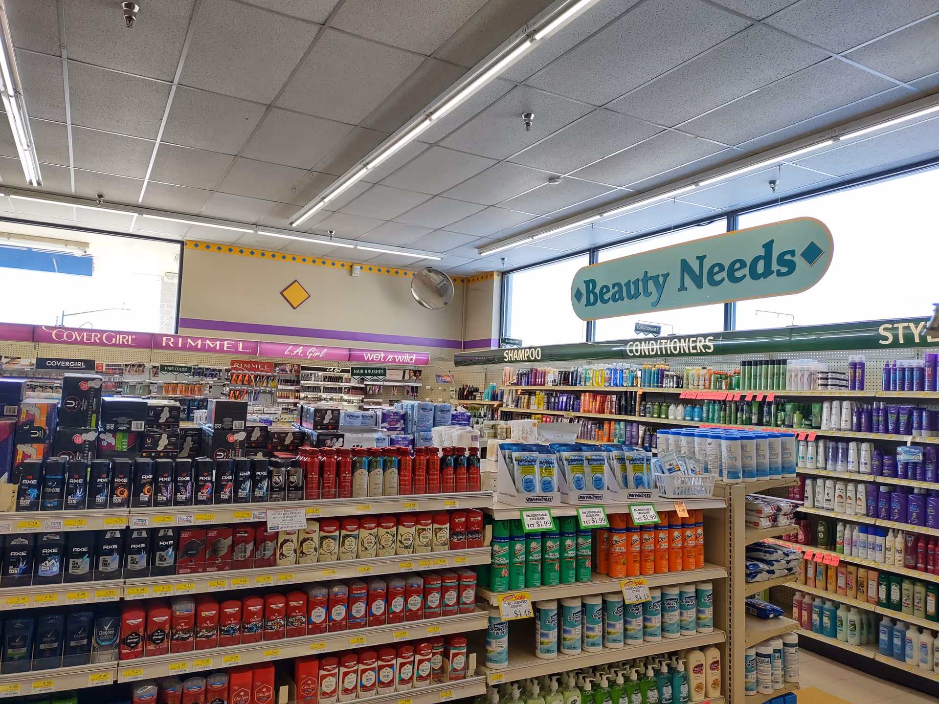 Inside a Discount Drug Mart store, shelves stocked with shampoos, conditioners, and personal care products.