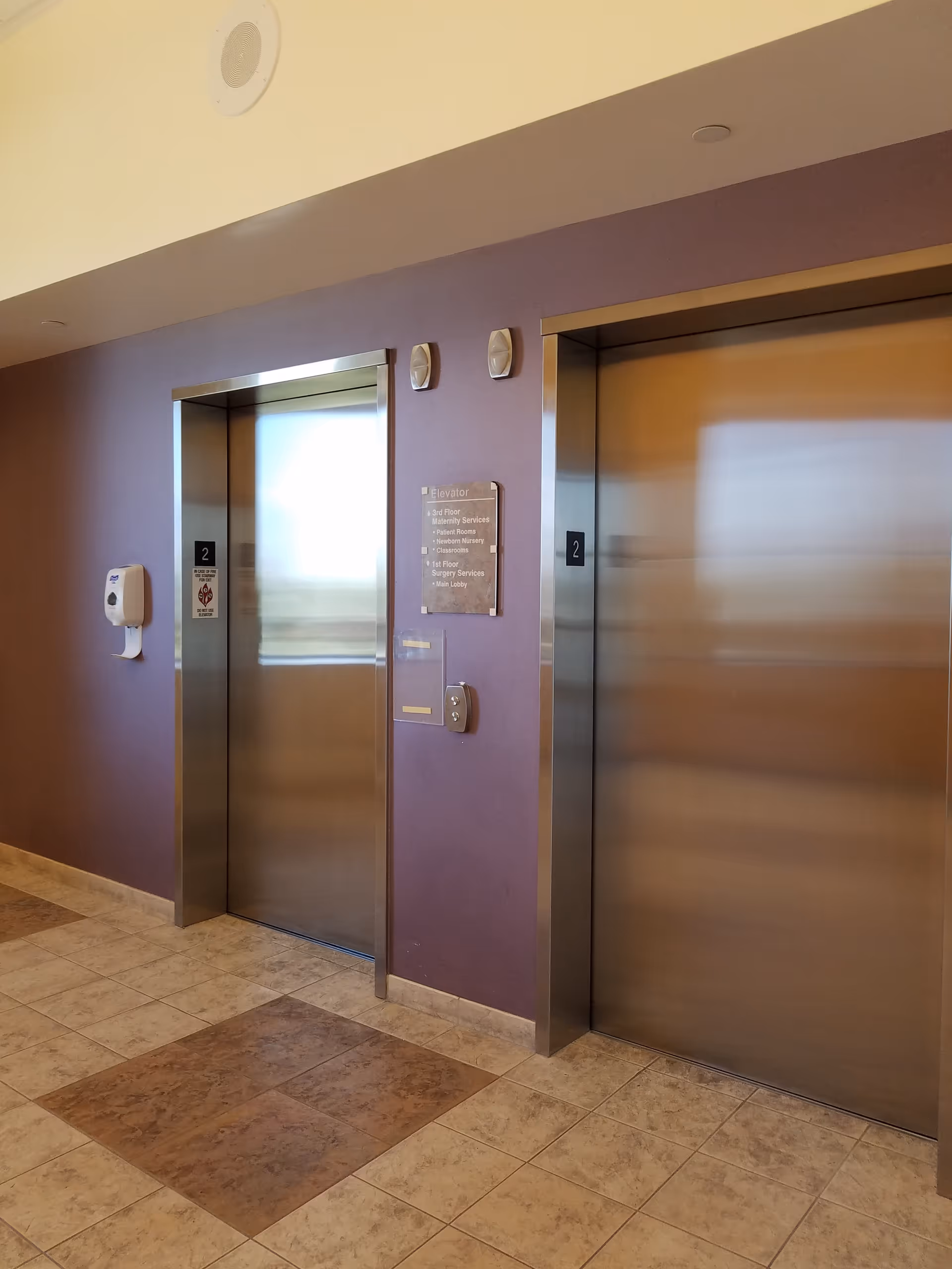 Redlands Community Hospital interior hallway with two stainless steel elevators.