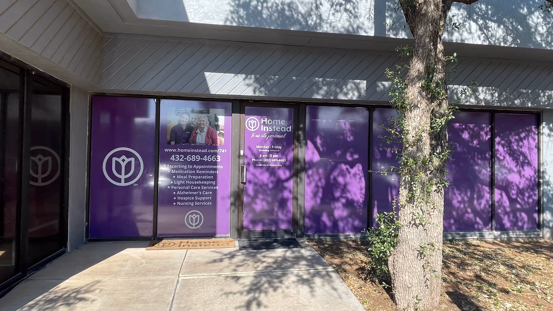 Exterior view of a Home Instead entrance with purple windows and logo.