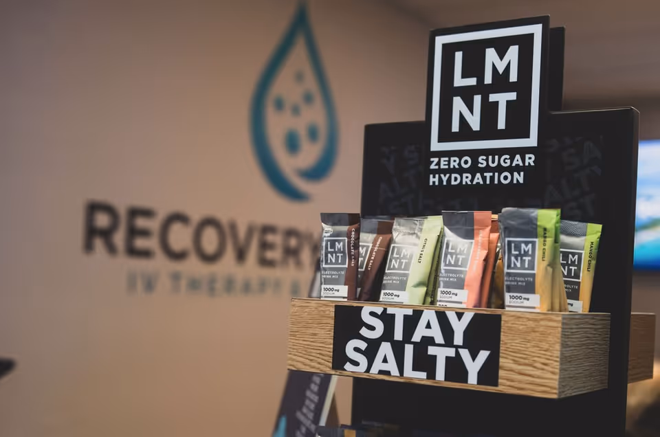 Indoor facility display showing LMNT hydration packets on a wooden stand with a Stay Salty sign.