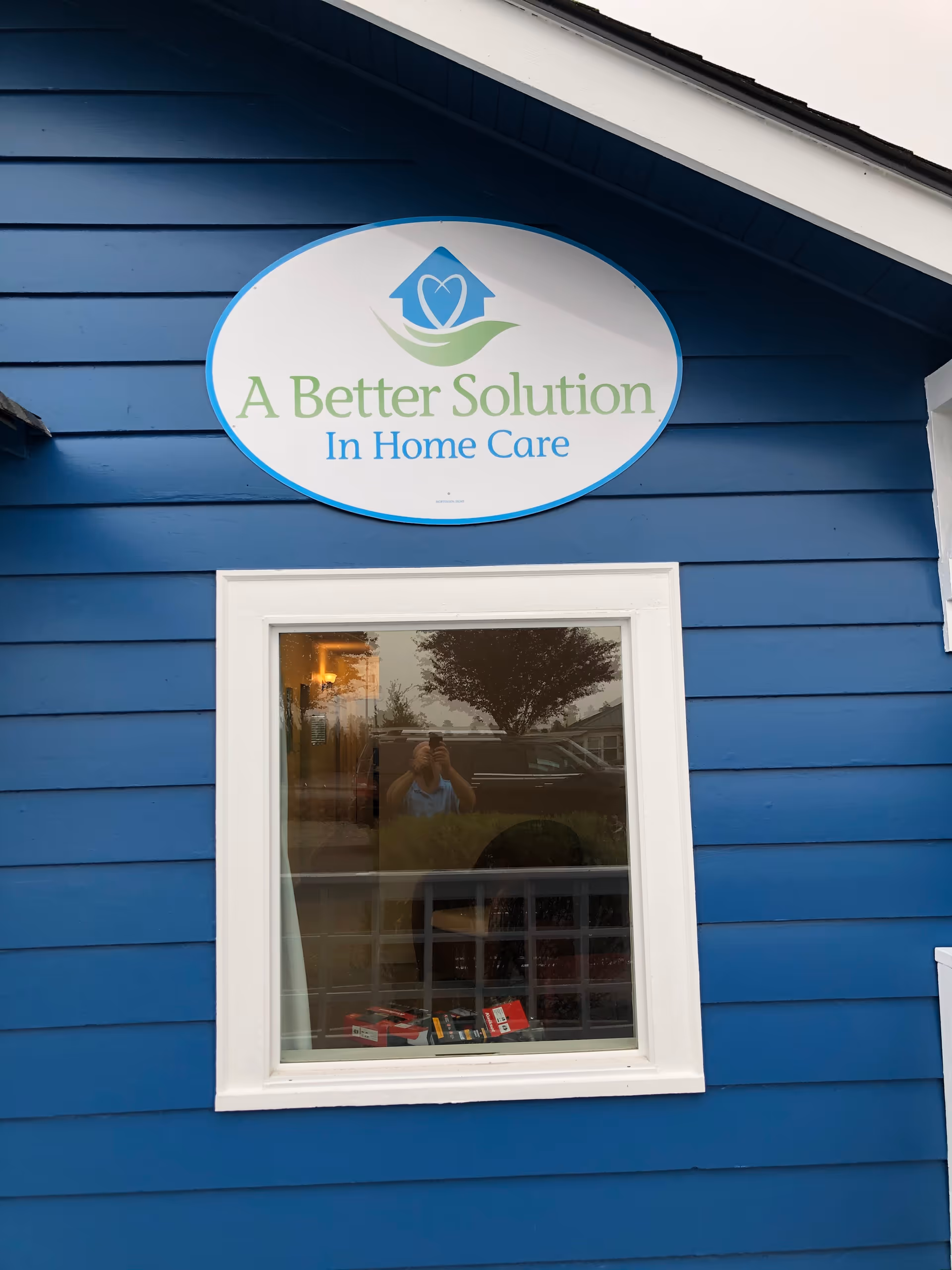 Blue building exterior featuring an oval sign: A Better Solution In Home Care.