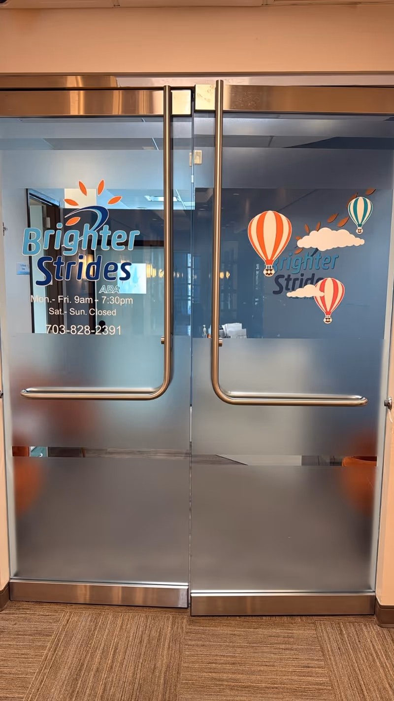 Glass double doors with Brighter Strides signage and hot air balloon graphics inside.