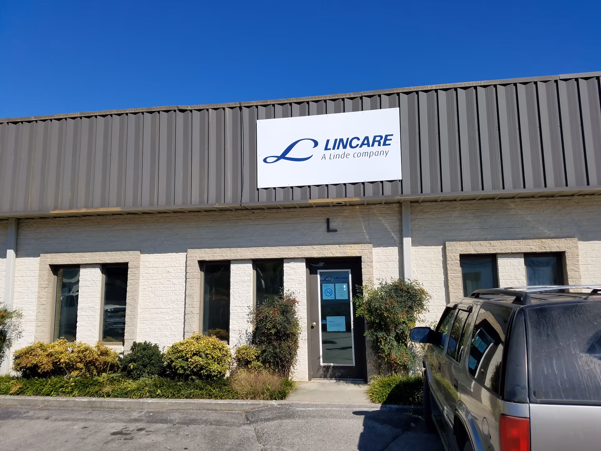 Exterior view of LINCARE facility with sign and entrance door.