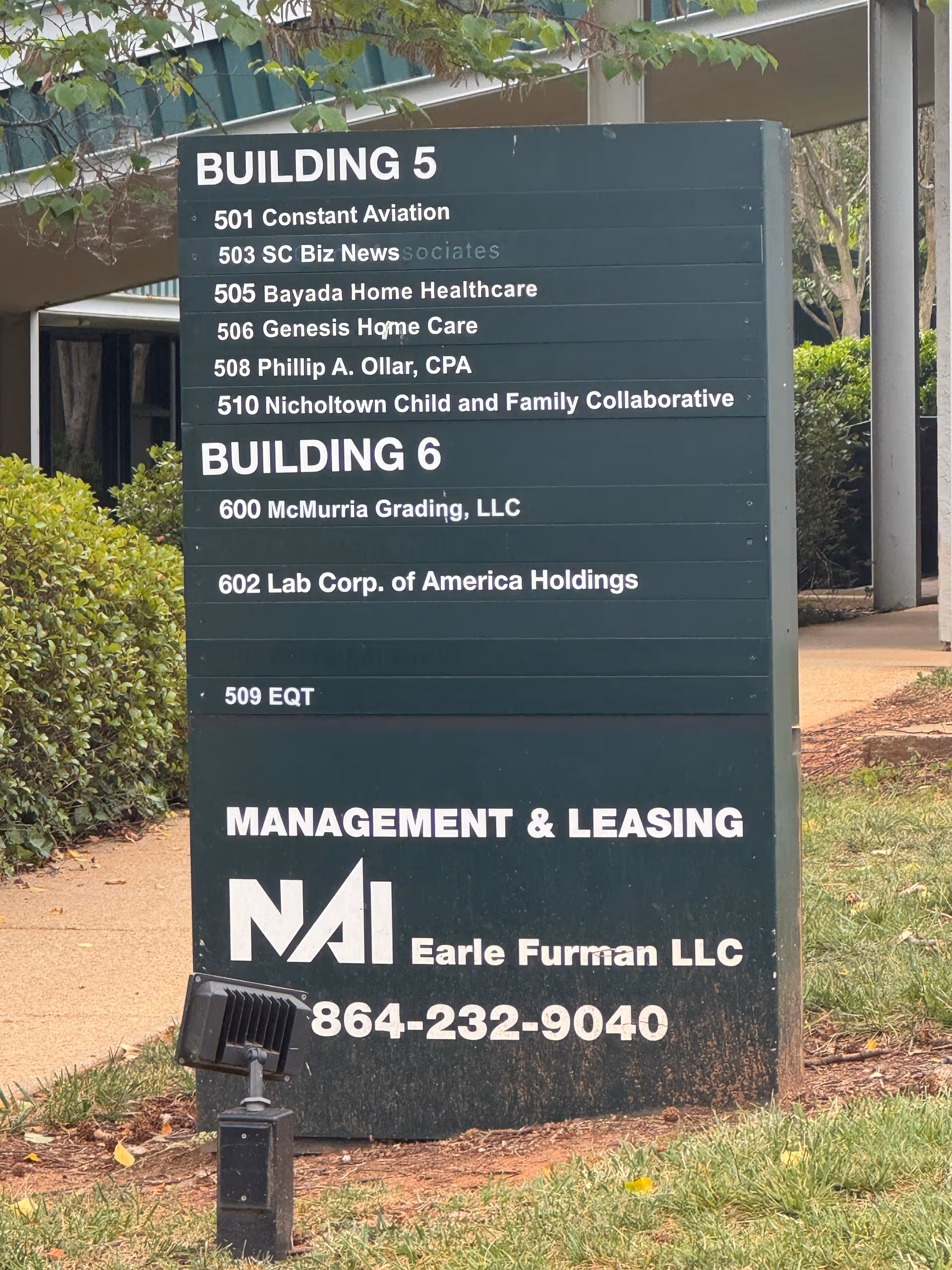 Green exterior directory sign listing offices and tenants, including Bayada Home Healthcare.