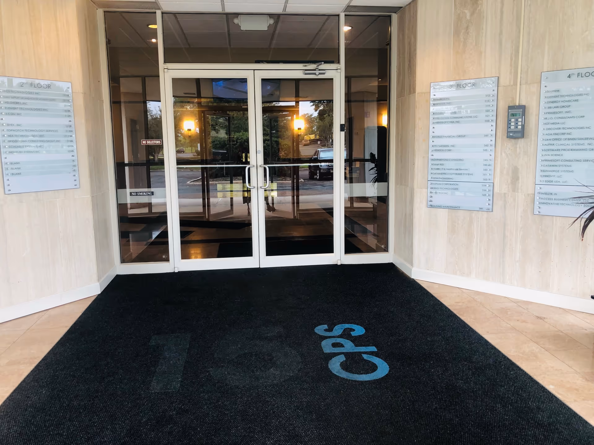 Double glass doors at a building entrance with wall directories
