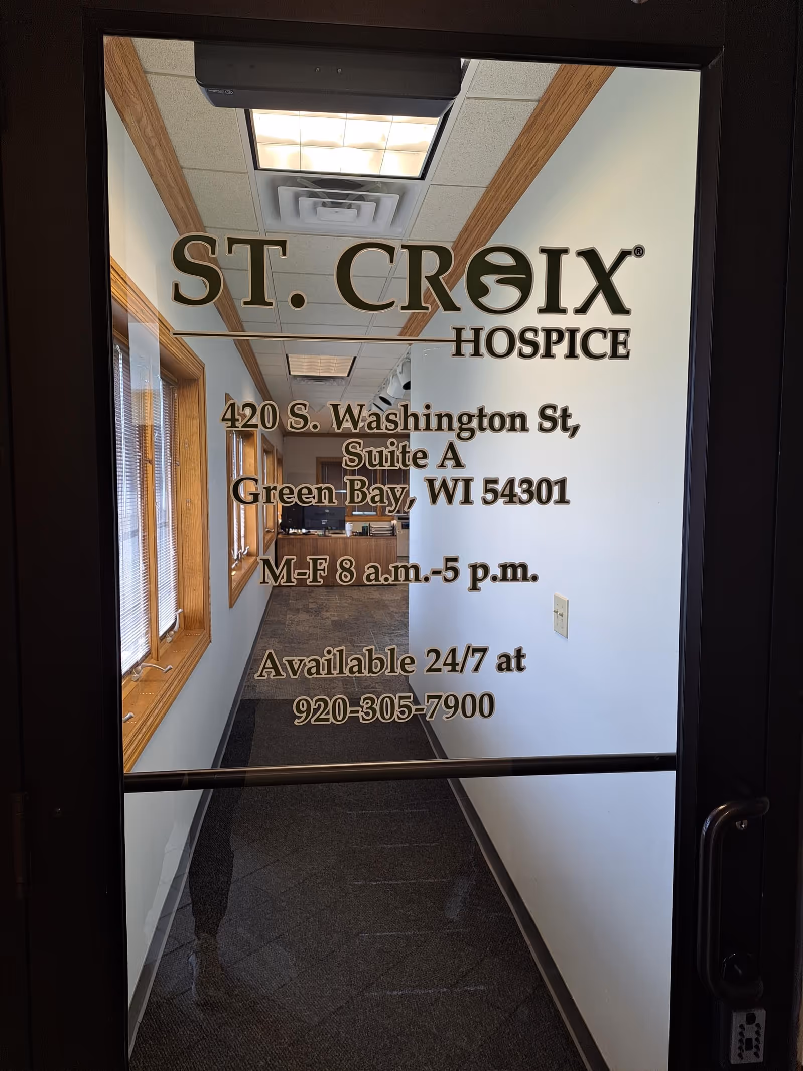Glass door shows St. Croix Hospice signage; a hallway is visible inside.