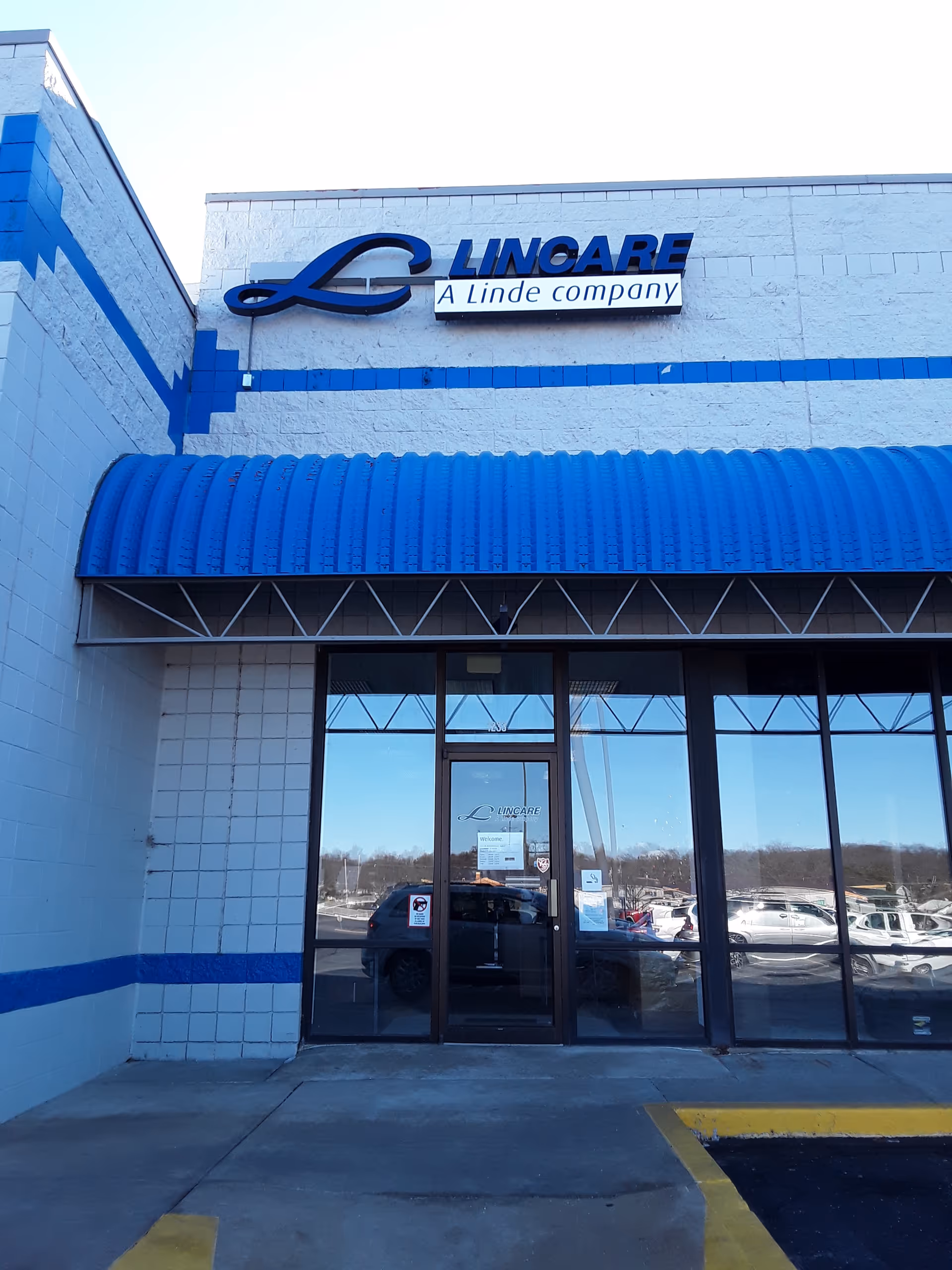 Front exterior of LINCARE building with blue awning and glass entrance doors