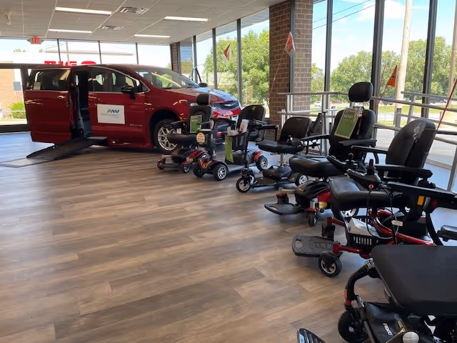 Indoor MobilityWorks showroom with a red vehicle and several mobility scooters.